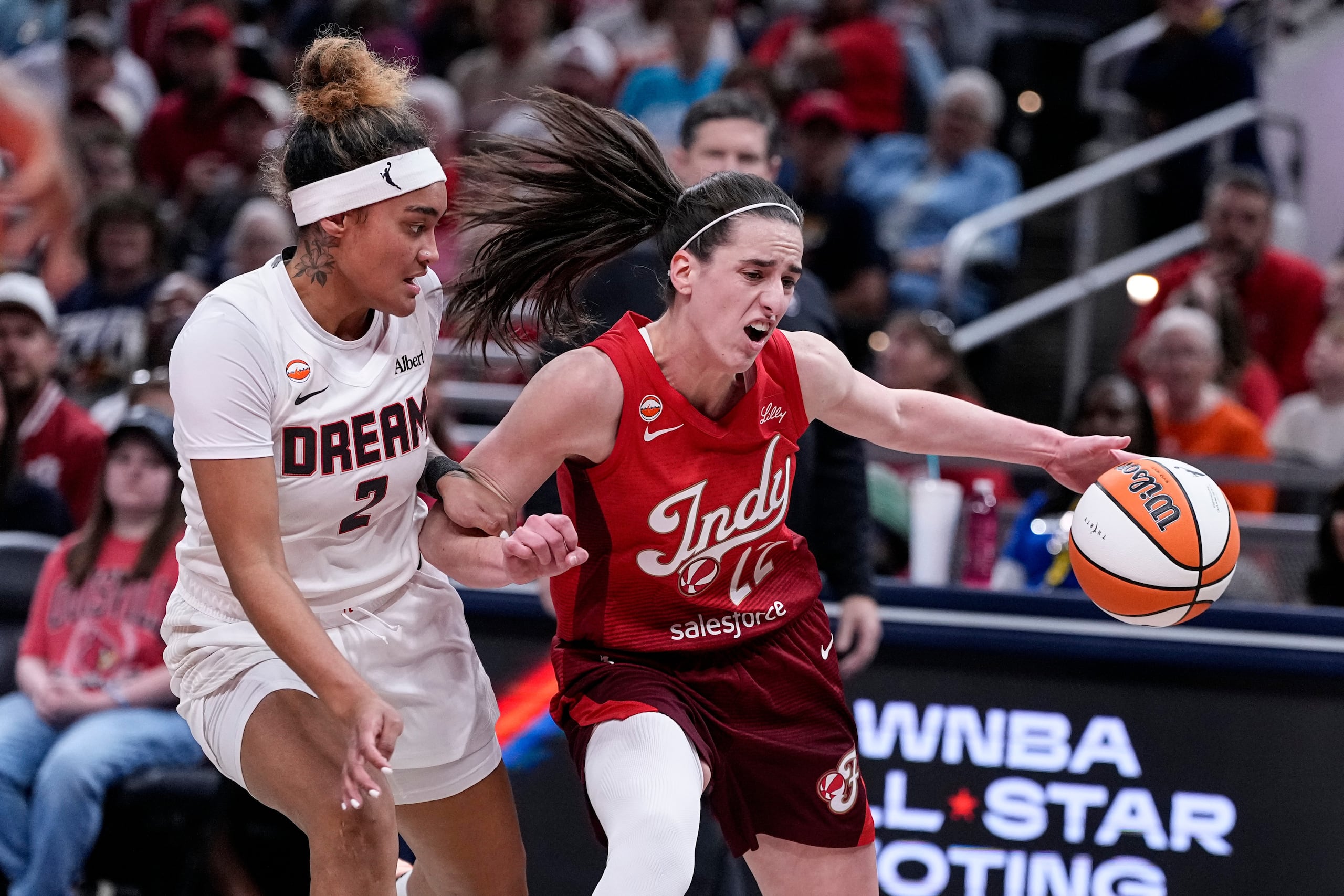 Indiana Fever guard Caitlin Clark (22) drives on Atlanta Dream guard Te-Hina Paopao (2) in the first half of a WNBA basketball game in Indianapolis, Thursday, June 18, 2026. (AP Photo/Michael Conroy)