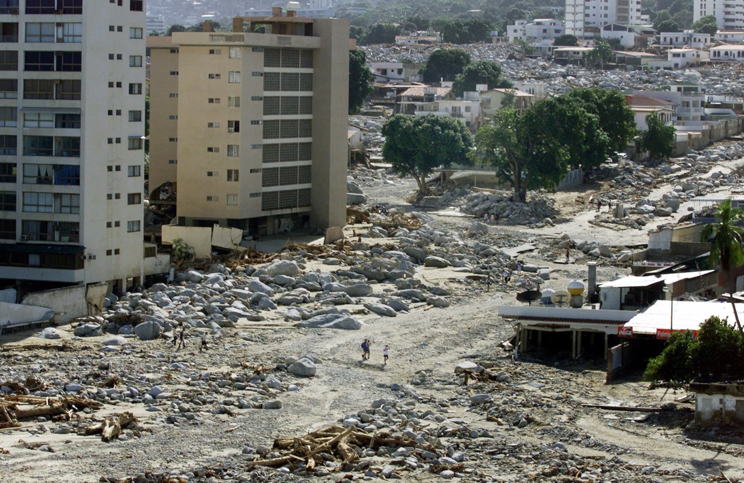 Sobrevivientes caminan por Macuto inundado, en el estado Vargas, justo al norte de la capital Caracas, el 19 de diciembre de 1999.