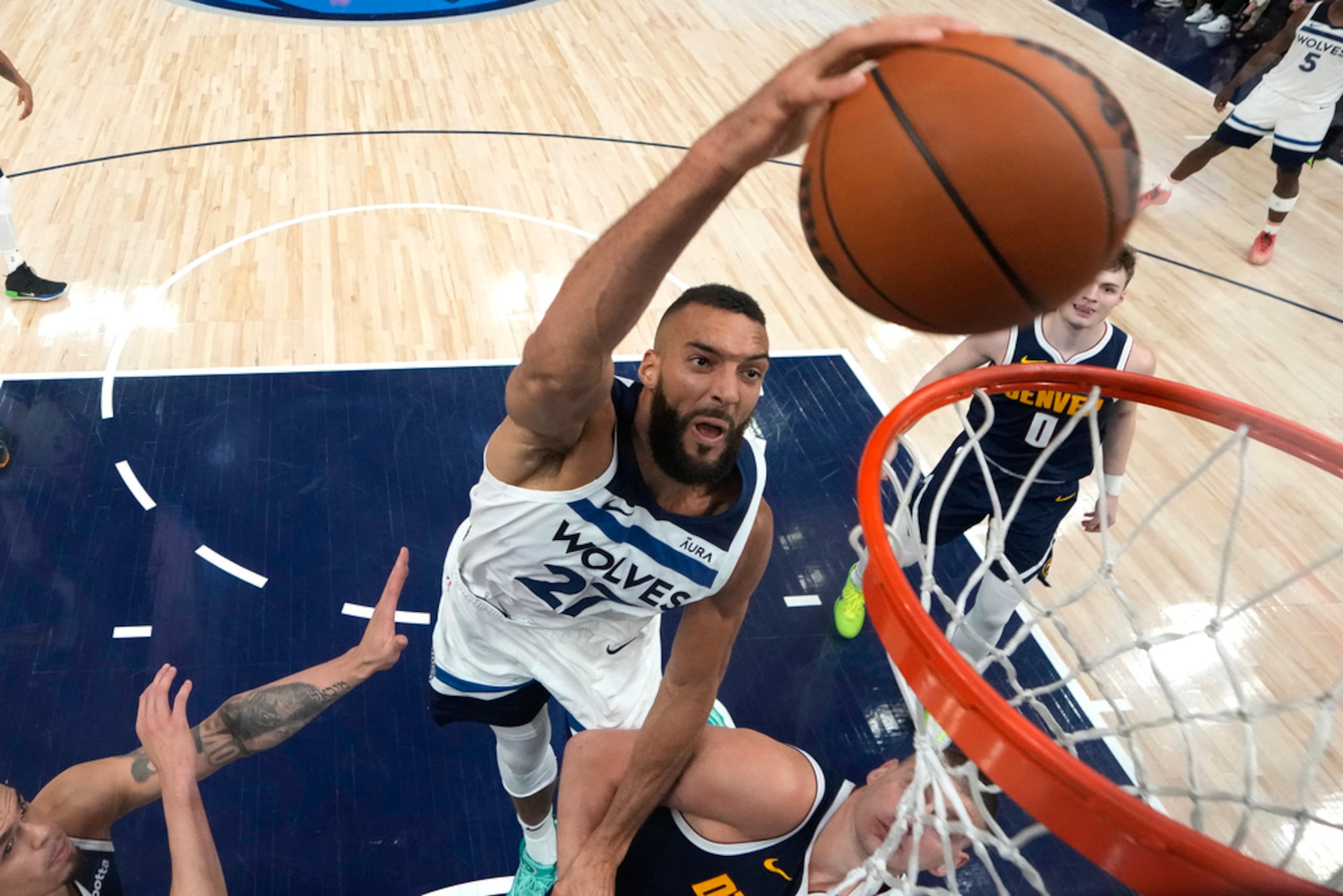 Rudy Gobert donquea por encima de Nikola Jokic durante el cuarto juego de la serie semifinal.