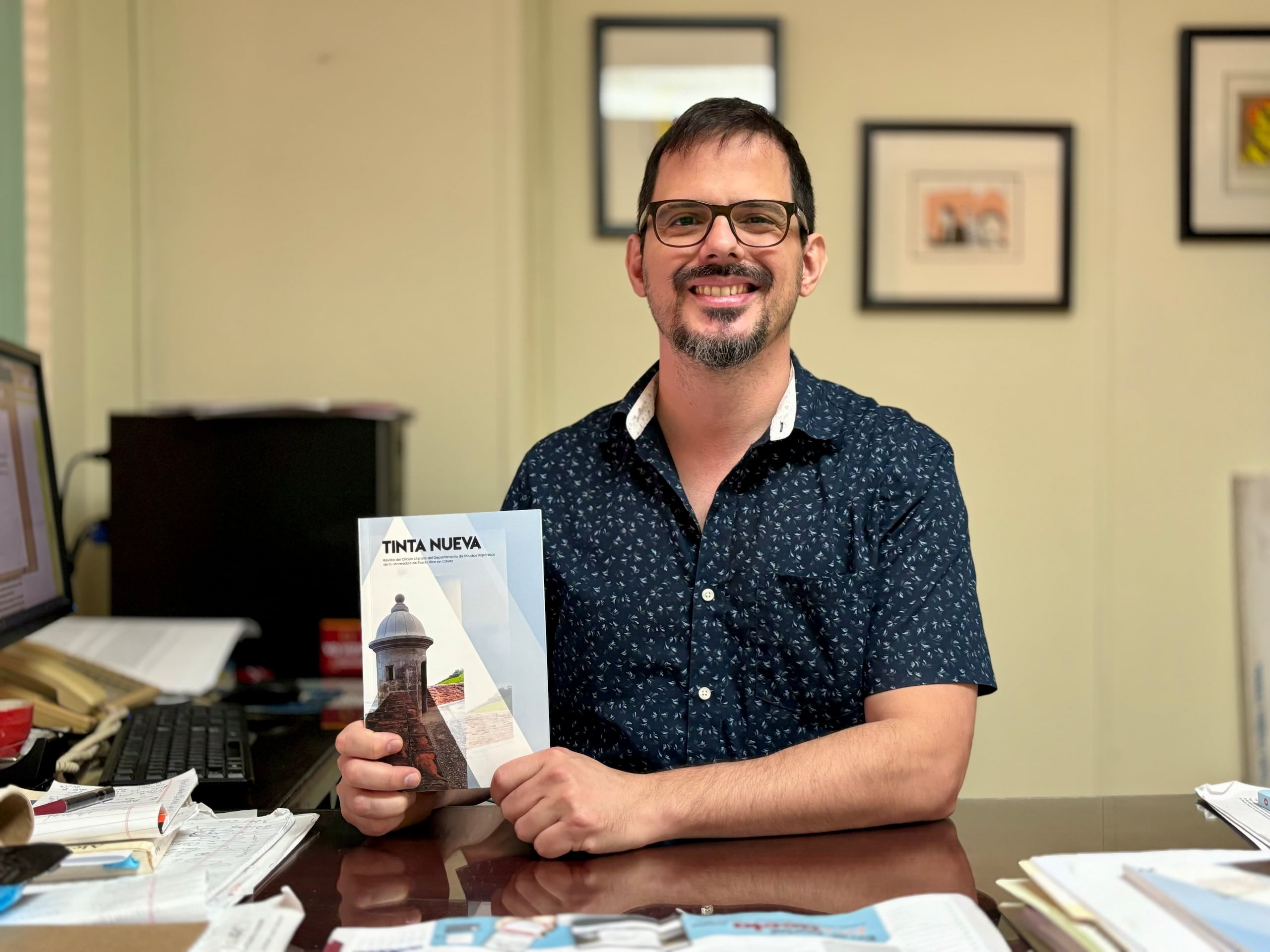 Alejandro Carpio, director del Departamento de Estudios Hispánicos de la UPR en Cayey, sostiene el más reciente ejemplar de la revista Tinta Nueva.