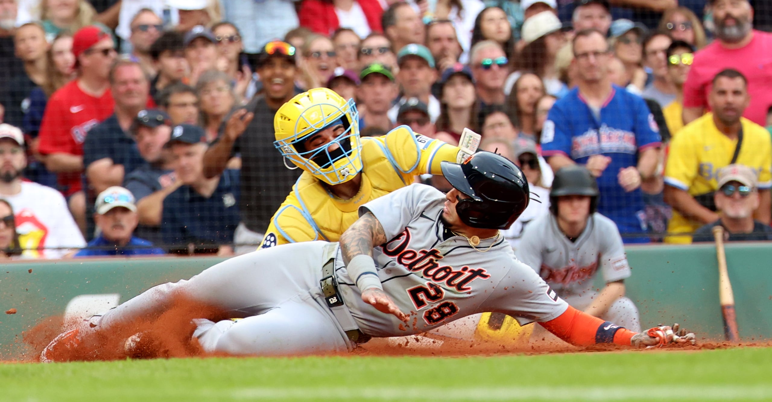 El puertorriqueño Javier Báez de los Tigers de Detroit se desliza en el plato frente al catcher venezolano Carlos Narváez.