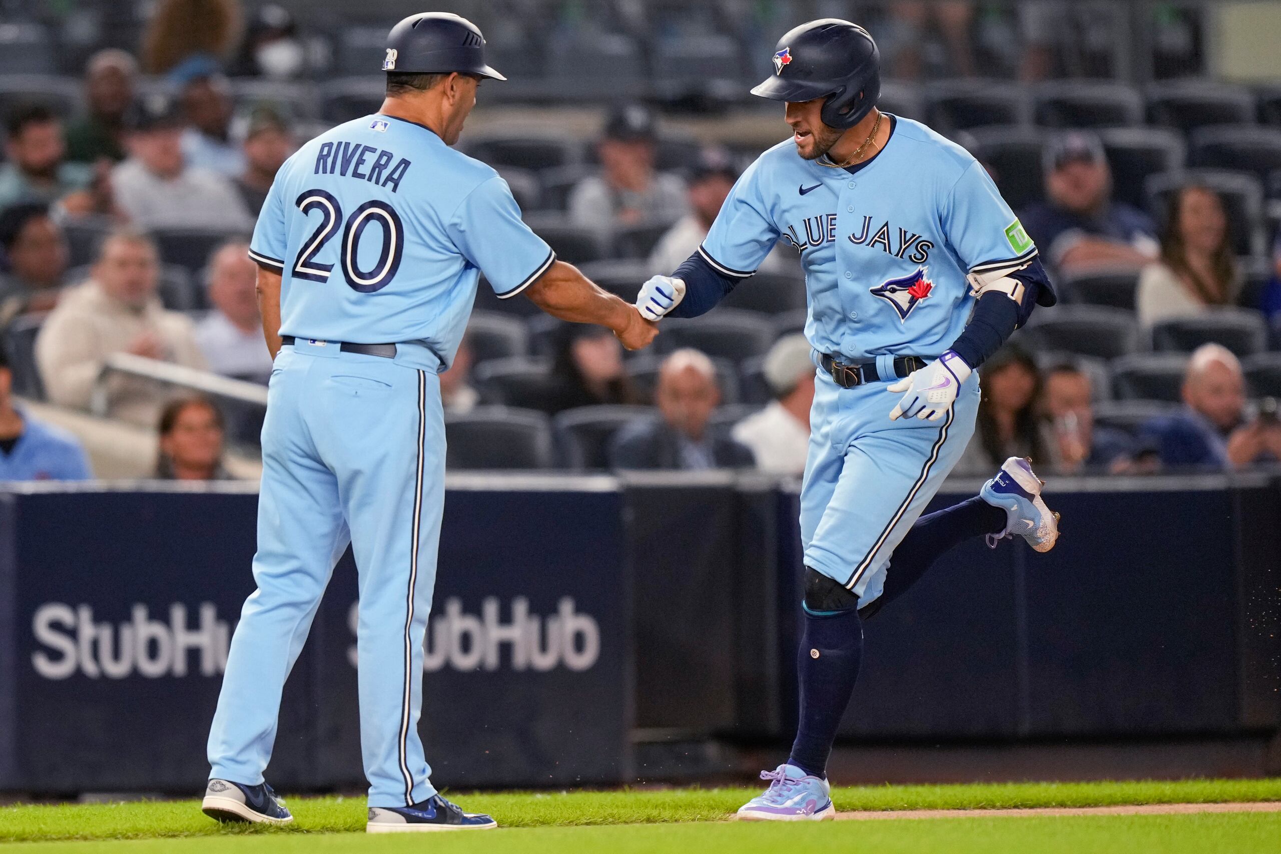 George Springer de los Blue Jays celebra con el entrenador de tercera base Luis 'Papa' Rivera (20) mientras recorre las bases luego de conectar un cuadrangular durante el juego ante los Yankees.
