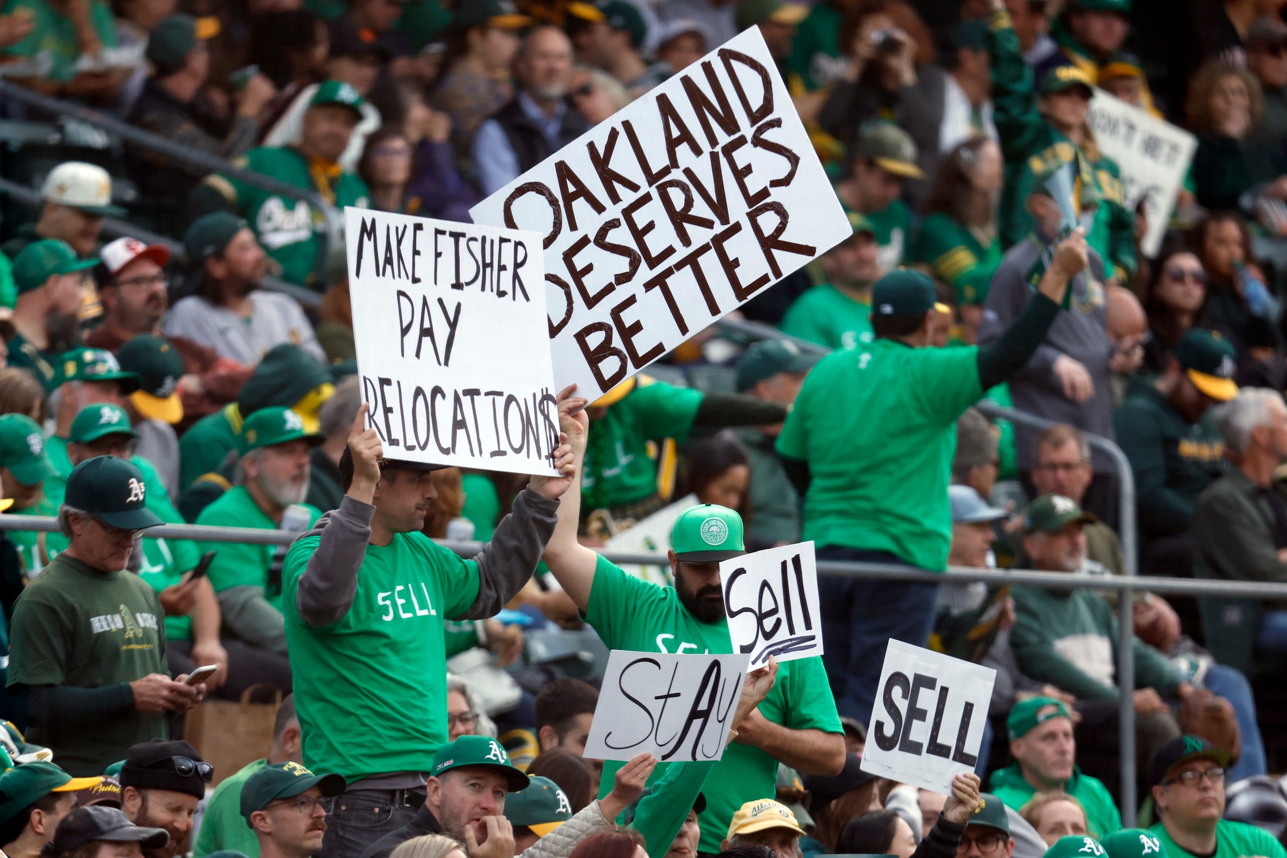 Fanáticos de los Athletics de Oakland muestran carteles pidiendo que el equipo no se mude a Las Vegas durante el juego del martes.