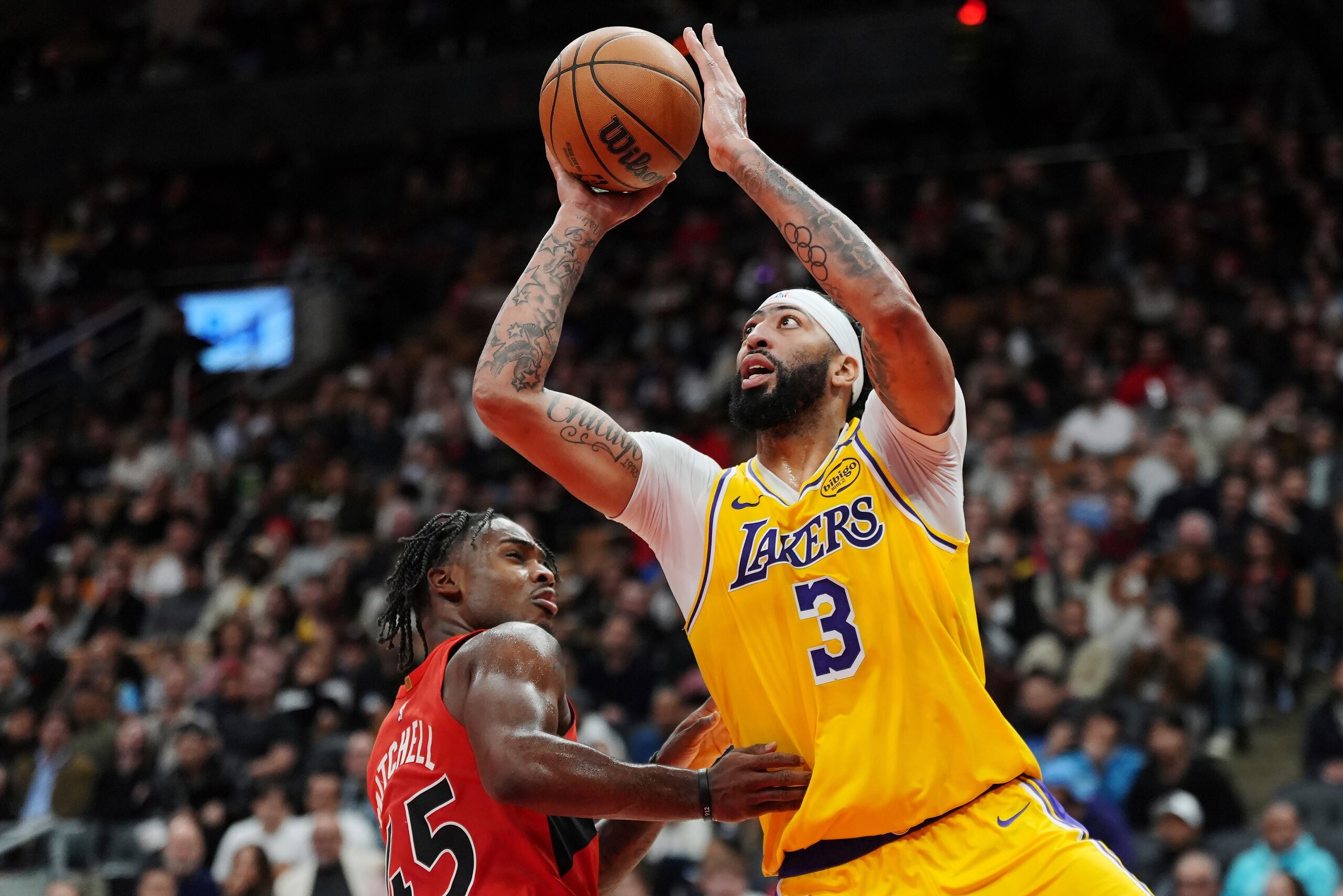 Anthony Davis, de los Lakers de Los Ángeles, lanza frente a Davion Mitchell, de los Raptors de Toronto, en el encuentro del viernes 1 de noviembre de 2024.