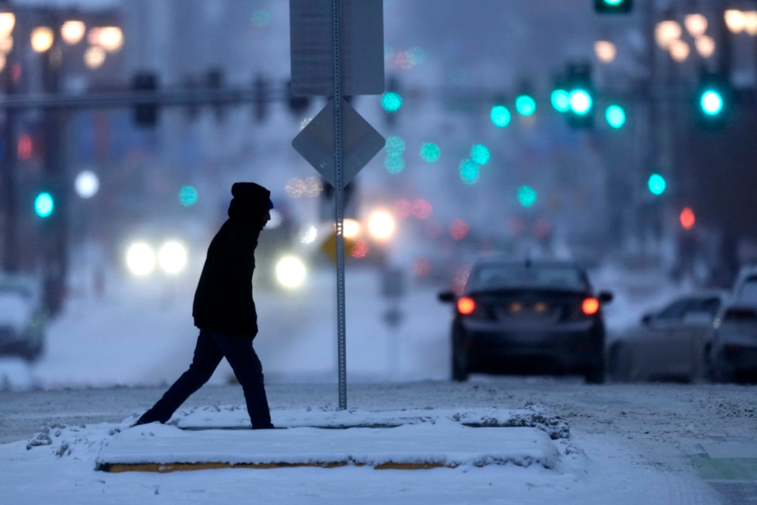 Un peatón desafía temperaturas bajo cero mientras camina el lunes en el centro de Kansas City, Missouri.