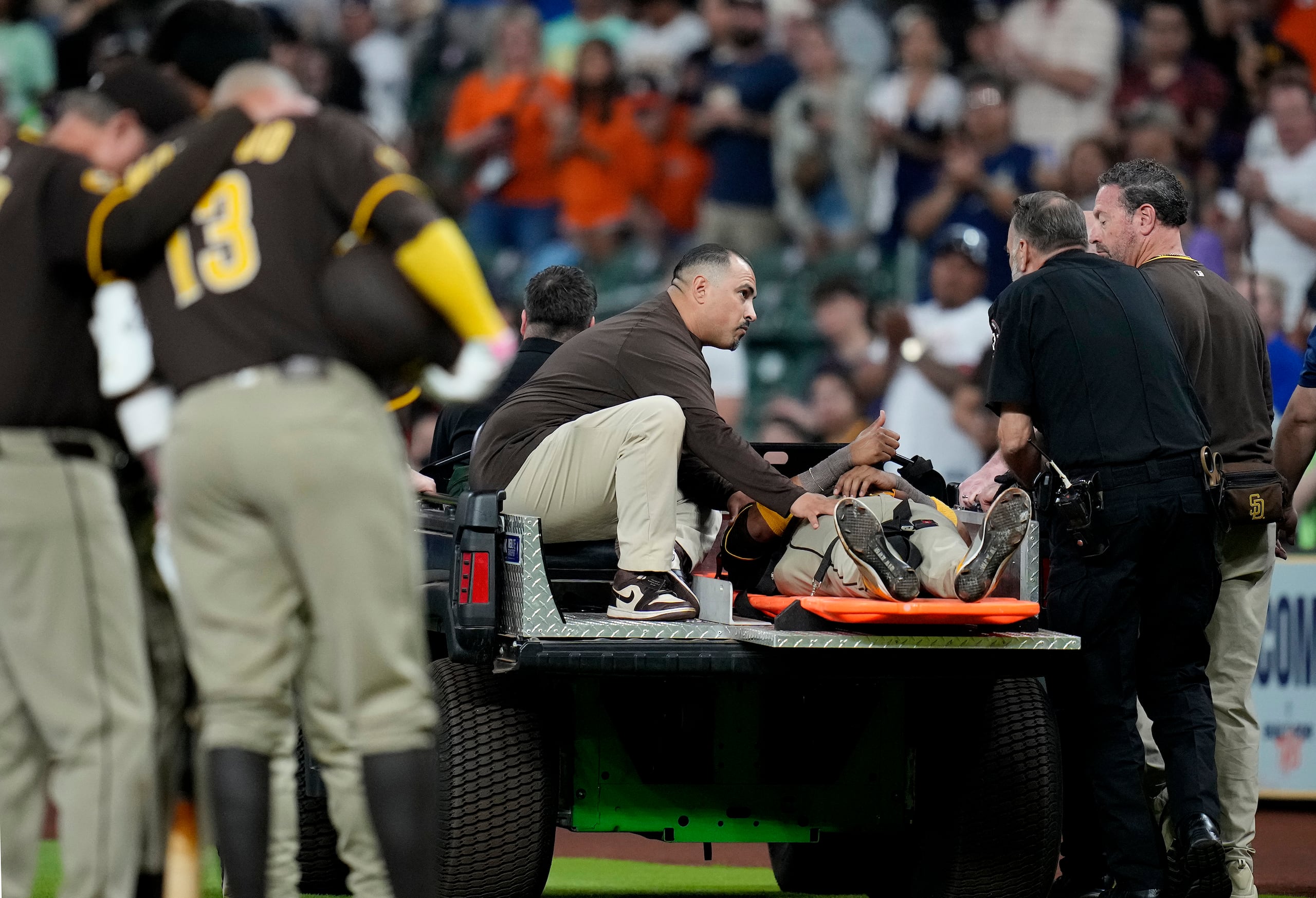 Luis Arráez, de los Padres de San Diego, levanta el pulgar cuando fue sacado del campo después de una colisión con el segunda base de los Astros de Houston, Mauricio Dubón, durante la primera entrada de un juego de béisbol el domingo 20 de abril de 2025, en Houston.