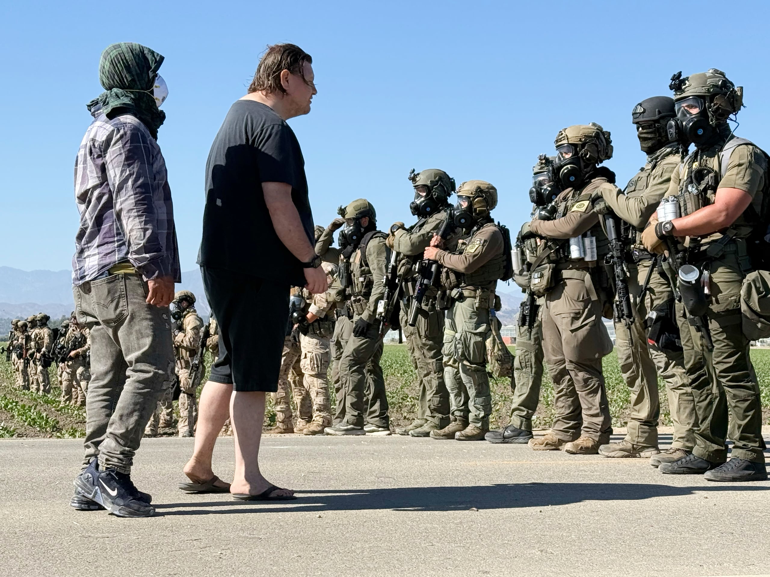 Manifestantes encaran a agentes federales que bloquean un camino durante una redada de inmigración en Camarillo, California. (Foto AP/Michael Owen Baker)