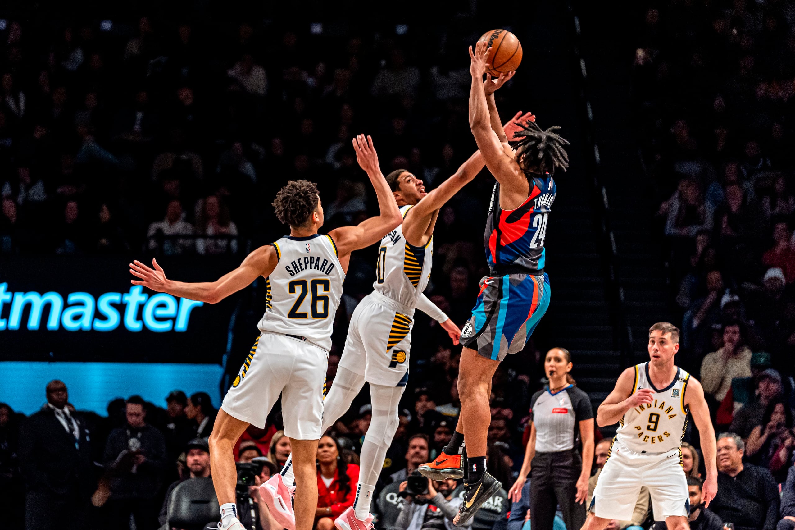 Cam Thomas (24), de los Nets de Brooklyn, dispara sobre Tyrese Haliburton (0) y Ben Sheppard (26), de los Pacers de Indiana, durante la segunda mitad de un partido de baloncesto de la NBA en Nueva York, el miércoles 3 de abril de 2024. (AP Foto/Peter K. Afriyie)