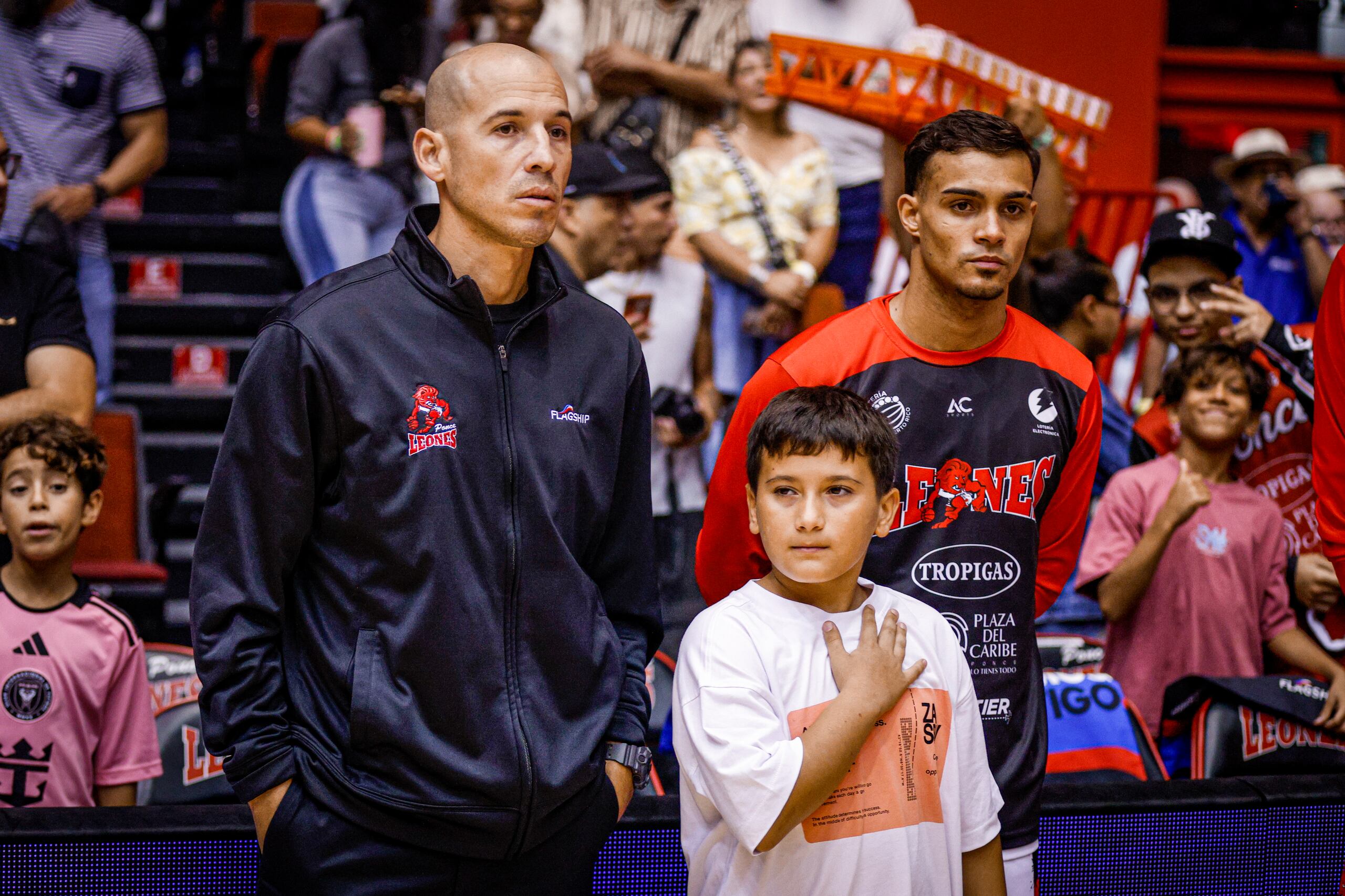 El dirigente Carlos Rivera, junto a su hijo menor Tiago, durante el partido de los Leones de Ponce este año.