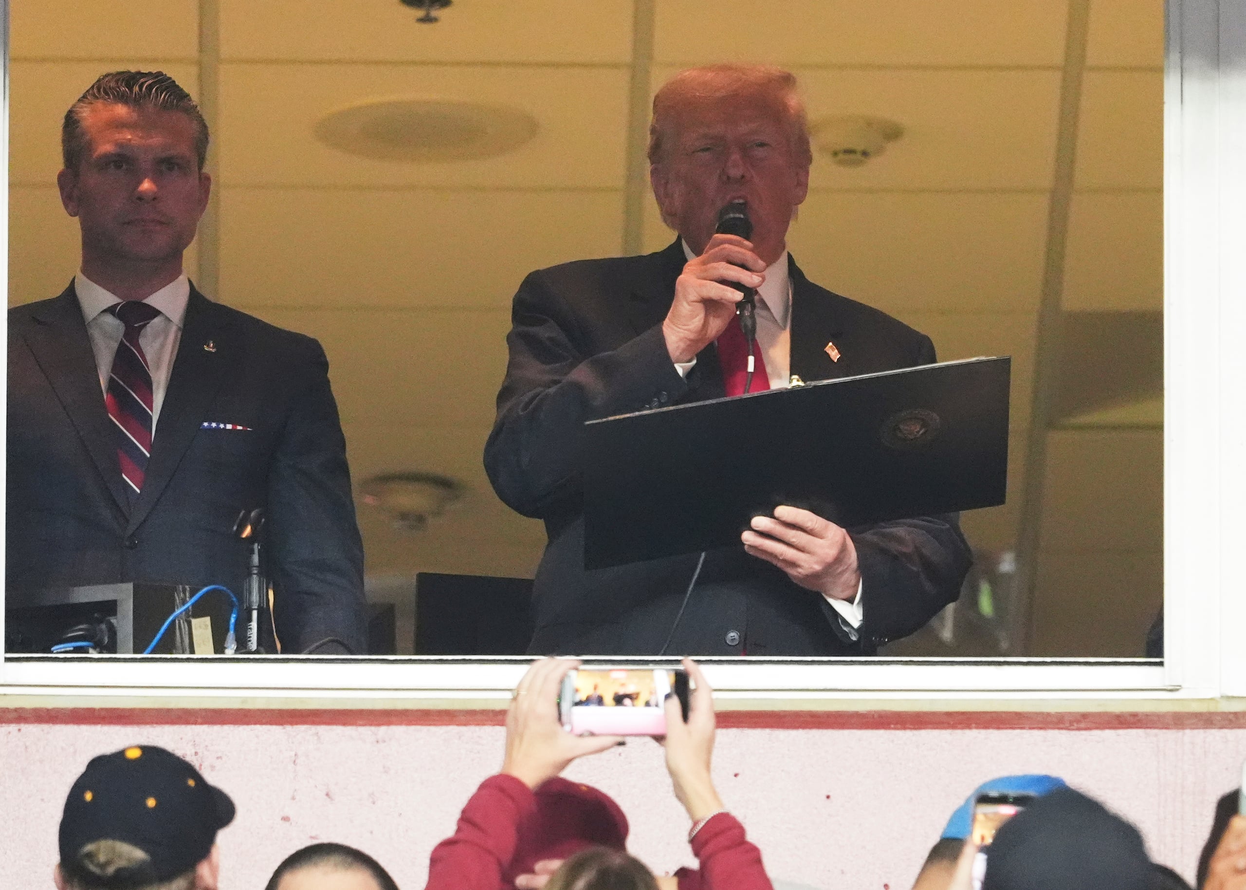 El presidente Donald Trump toma el juramento de alistamiento junto al secretario de Defensa, Pete Hegseth, a la izquierda, durante un partido de fútbol americano de la NFL entre los Commanders de Washington y los Lions de Detroit en el Northwest Stadium en Landover, Maryland, el domingo 9 de noviembre de 2025. (Foto AP/Jacquelyn Martin)