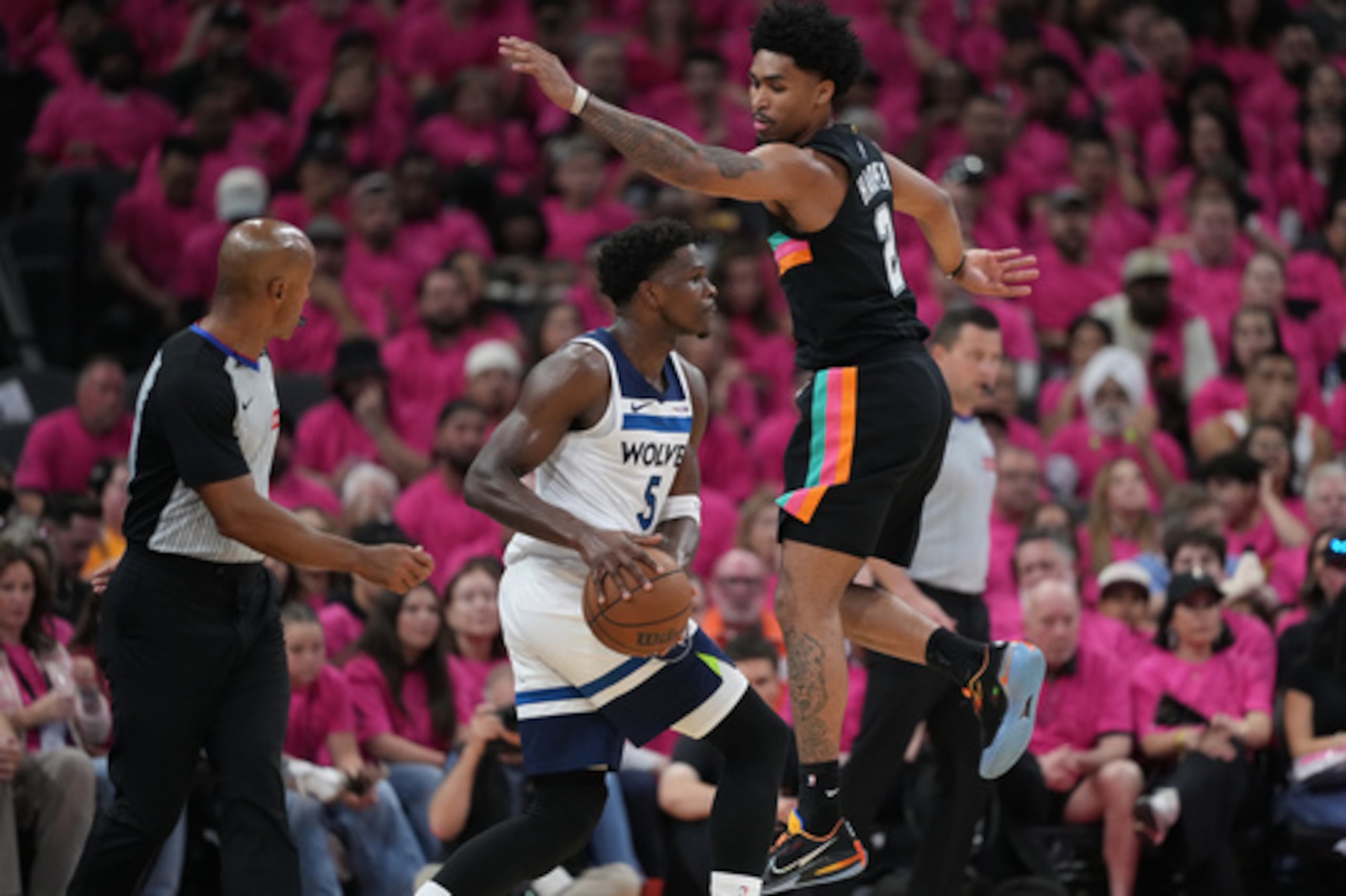 El escolta de los Minnesota Timberwolves Anthony Edwards (5) maneja el balón mientras el escolta de los San Antonio Spurs Dylan Harper (2) defiende durante la primera mitad en el Juego 1 de una serie de segunda ronda de los playoffs de baloncesto de la NBA en San Antonio, el lunes 4 de mayo de 2026. (AP Photo/Eric Gay)