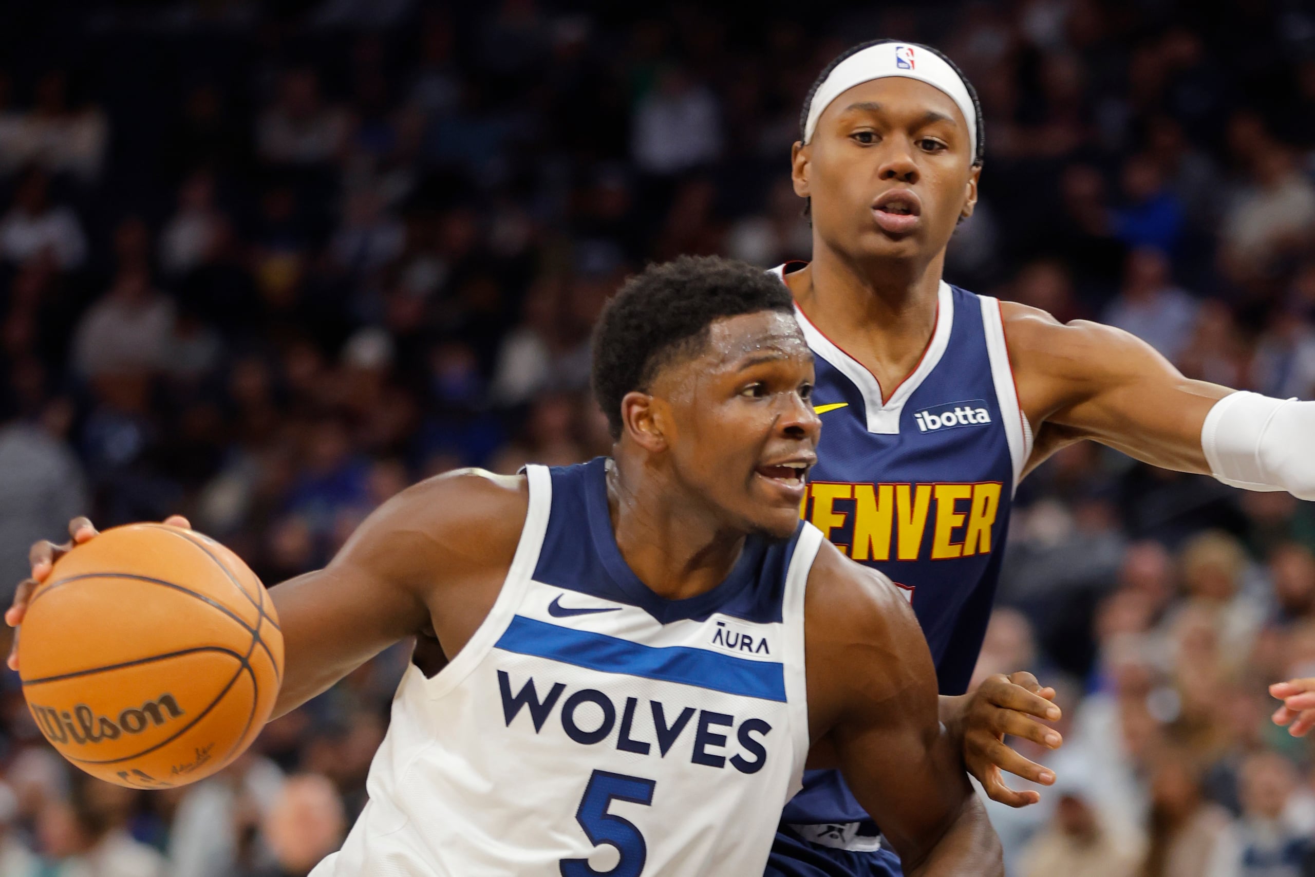 Anthony Edwards, base de los Timberwolves de Minnesota, elude a Peyton Watson, de los Nuggets de Denver.