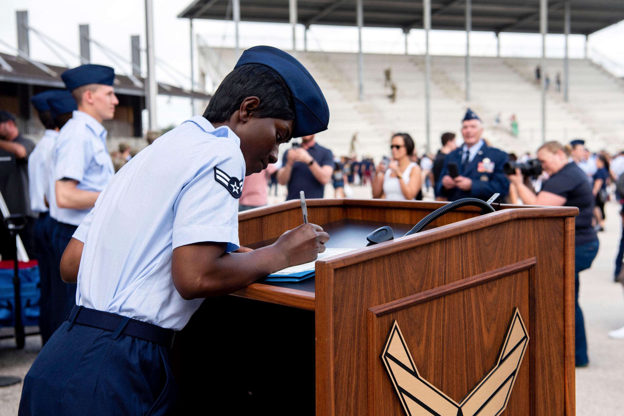 La aviadora de primera clase D'elbrah Assamoi, de Costa de Marfil, firma su certificado de ciudadanía estadounidense al final de una ceremonia de entrenamiento militar básico en la Base Conjunta San Antonio-Lackland, en San Antonio, Texas.