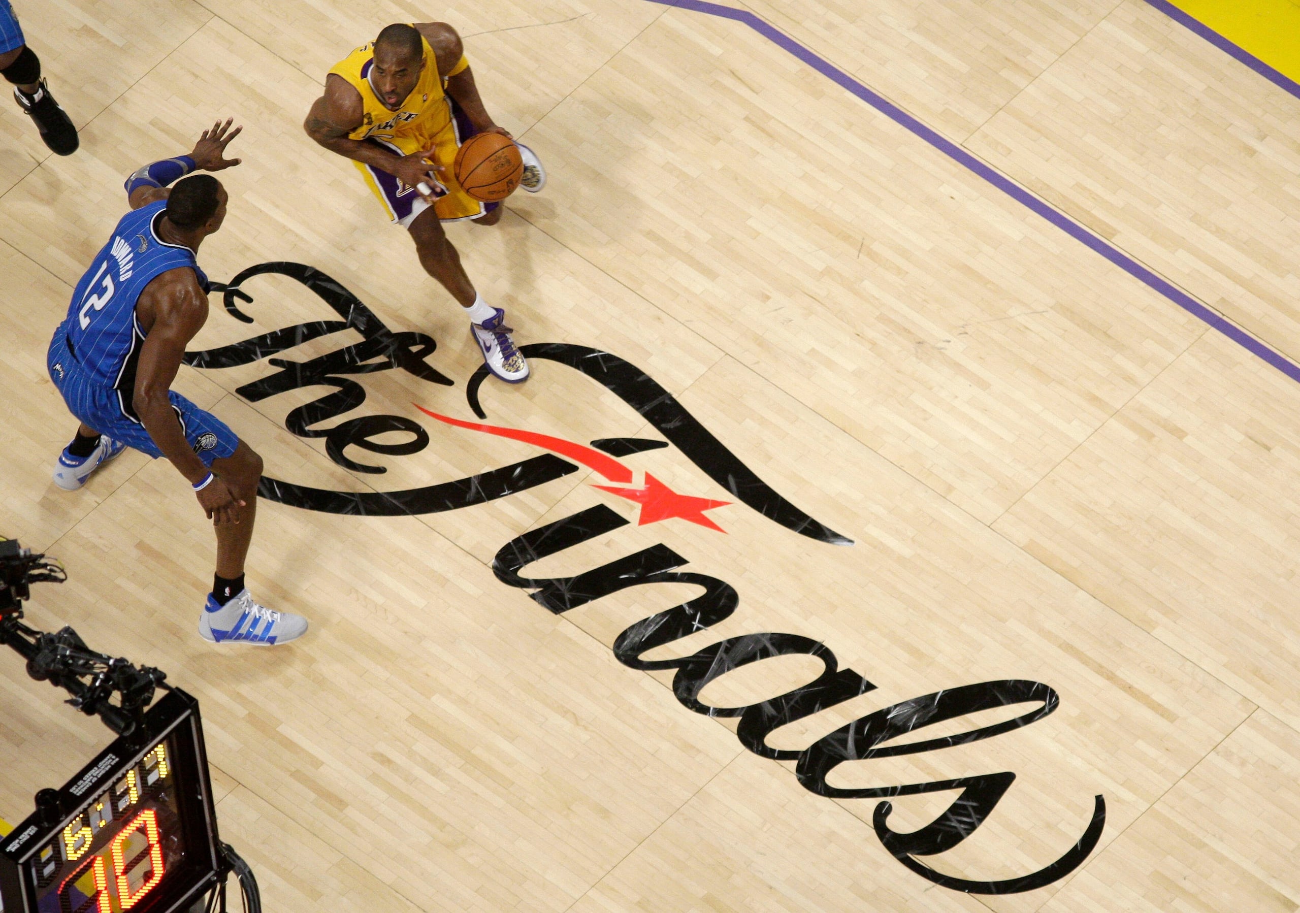 ARCHIVO - El escolta de los Lakers de Los Ángeles, Kobe Bryant, driblea el balón ante la defensa del pívot deL Magic de Orlando, Dwight Howard en el 2009.