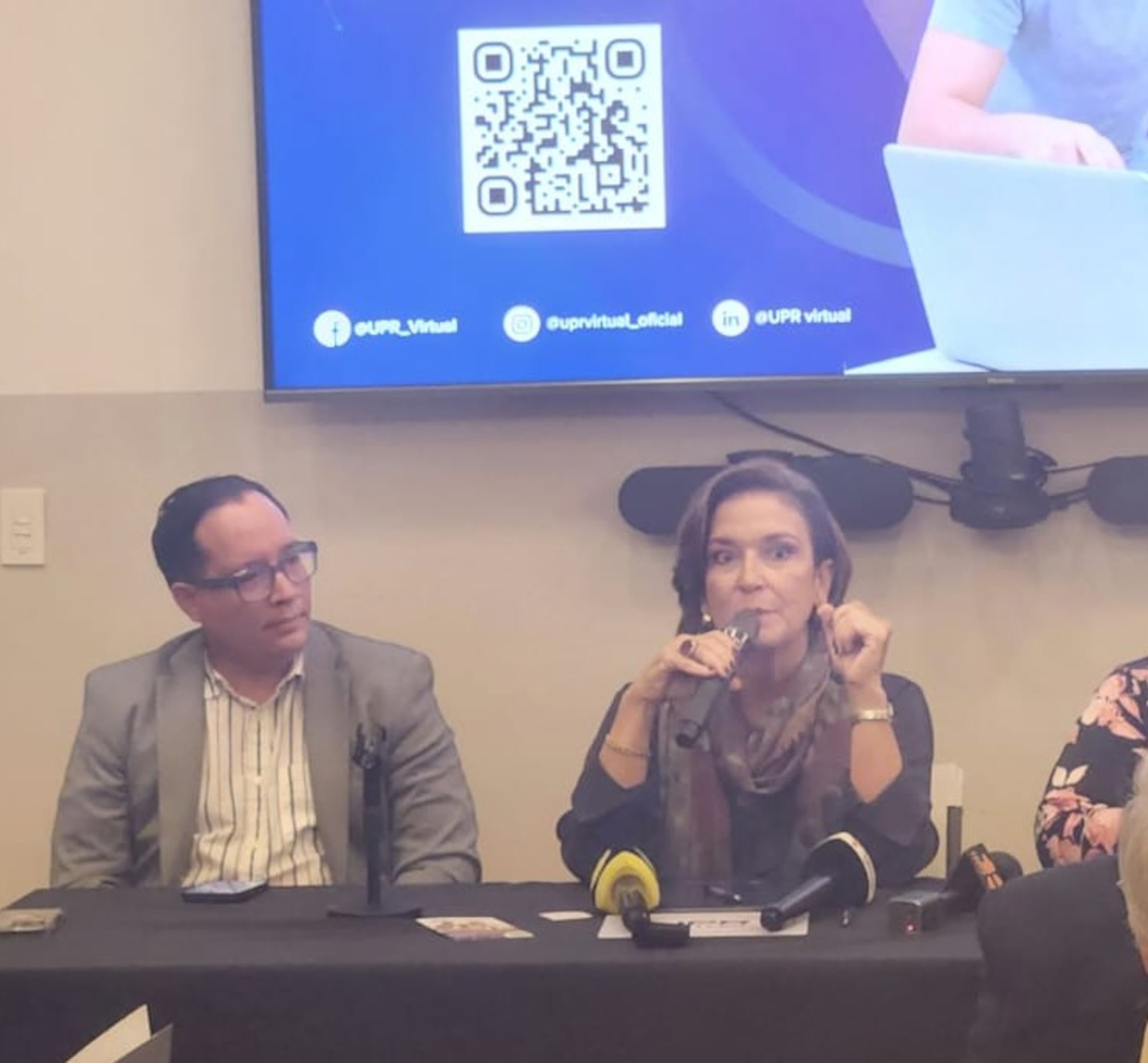 La presidenta de la UPR, Zayira Jordán, presenta la plataforma UPR Virtual. Le observa el vicepresidente asociado de Asuntos Estudiantiles, Alfred Díaz Meléndez.