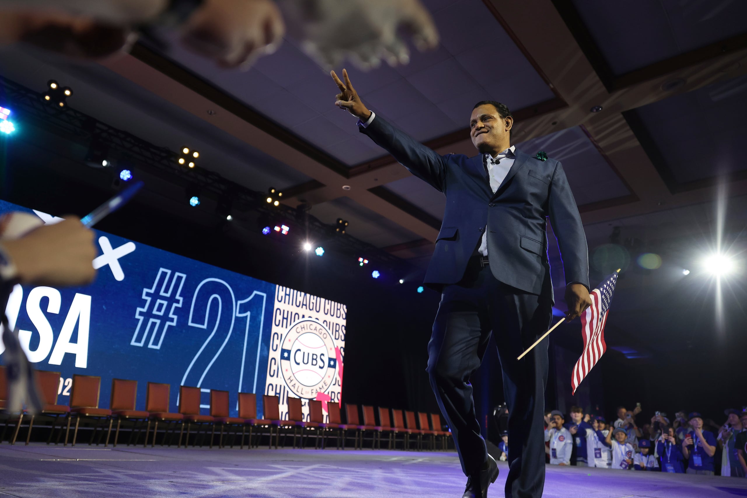El exjugador de los Cubs, Sammy Sosa, hace gestos a los fanáticos mientras es presentado durante la ceremonia de apertura de la Convención de los Cubs en el Sheraton Grand Chicago Riverwalk el viernes 17 de enero de 2025, en Chicago