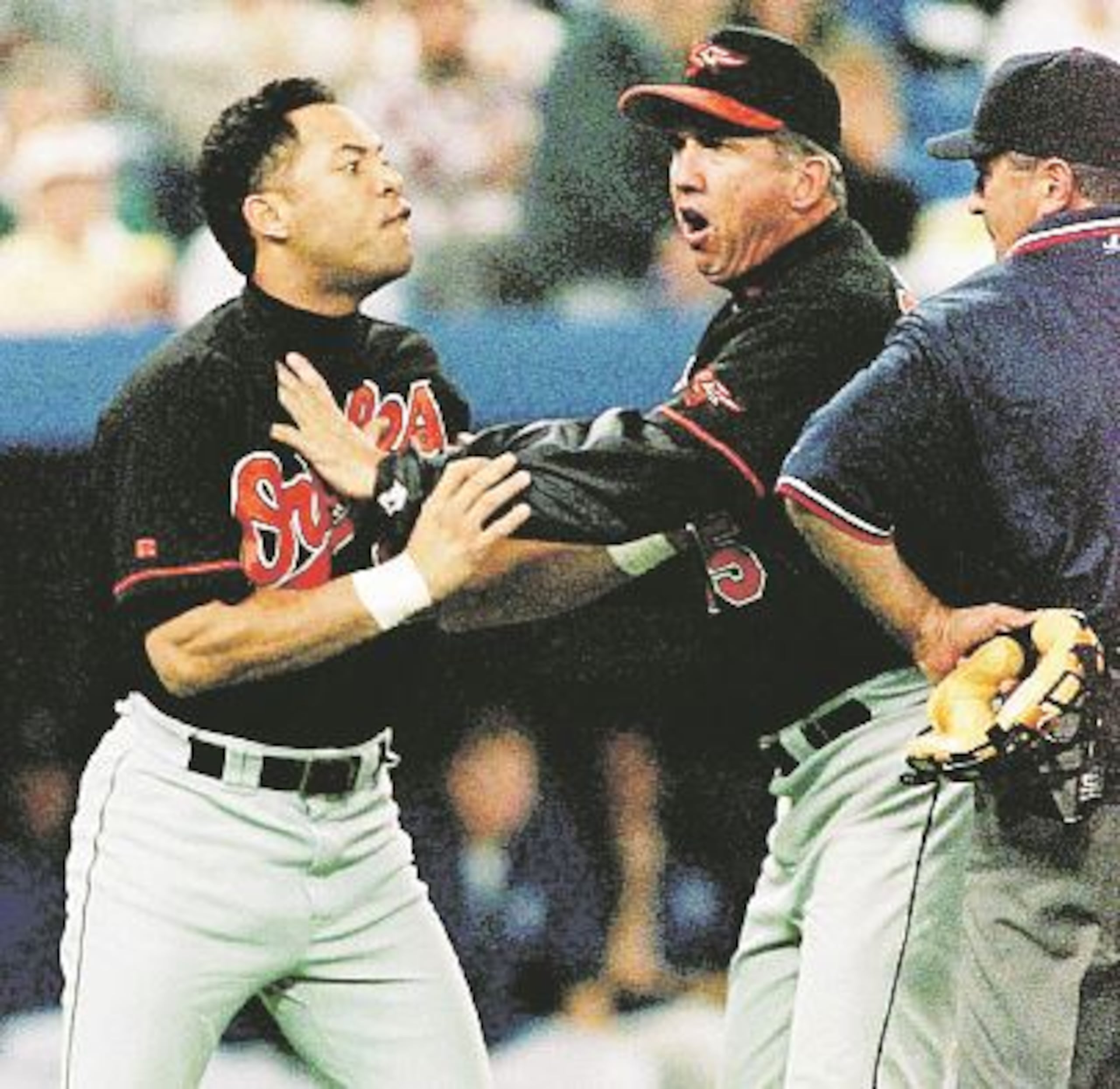 Alomar es aguantado por el dirigente Davey Johnson mientras discute con el árbitro John Hirschbeck, a quien Alomar escupió en el incidente. (AP / Moe Doiron)