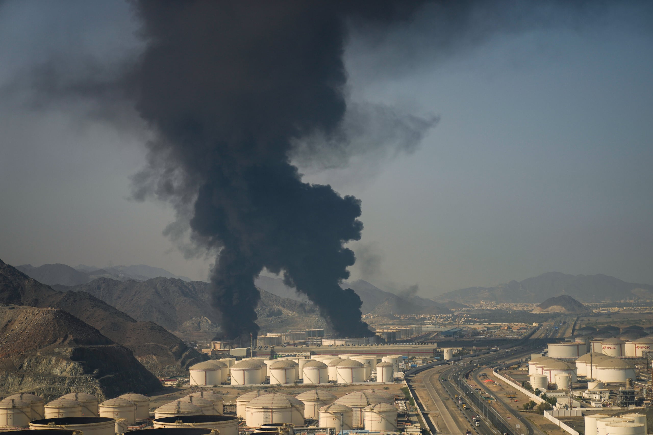 Fuego y columnas se alzan de una instalación petrolera en Fujairah, Emiratos Árabes Unidos, el sábado 14 de marzo de 2026. (AP Foto/Altaf Qadri)