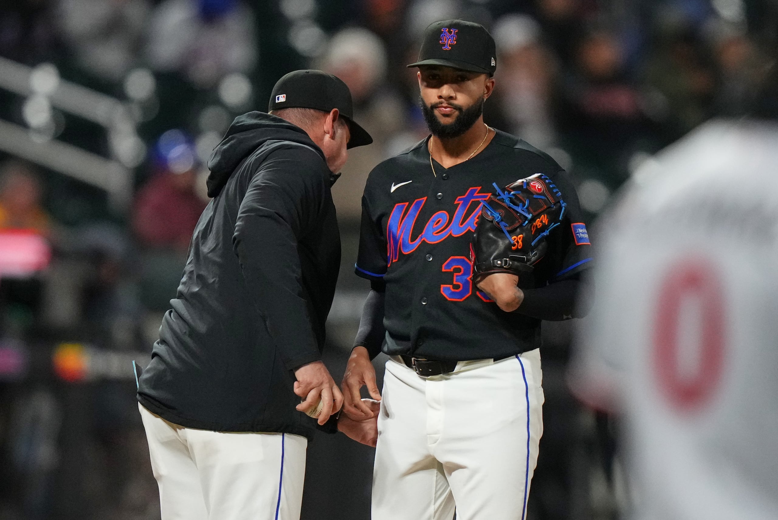 El lanzador de los Mets de Nueva York, Devin Williams (derecha), le entrega la pelota al mánager Carlos Mendoza al salir durante la novena entrada de un partido de béisbol contra los Mellizos de Minnesota, el martes 21 de abril de 2026, en Nueva York. (AP Foto/Frank Franklin II)