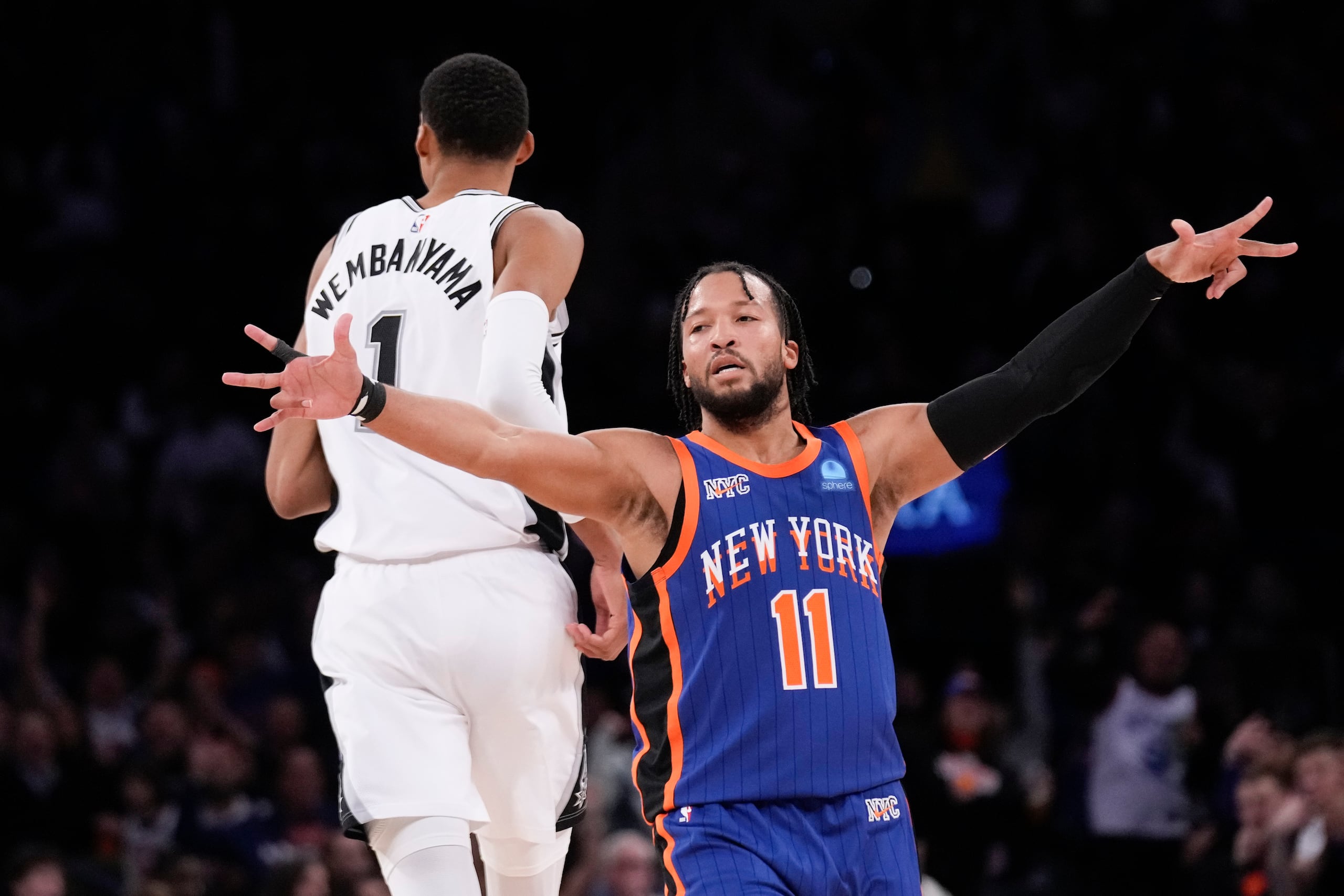 Jalen Brunson, de los Knicks de Nueva York, festeja tras encestar, detrás de Victor Wembanyama, de los Spurs de San Antonio.