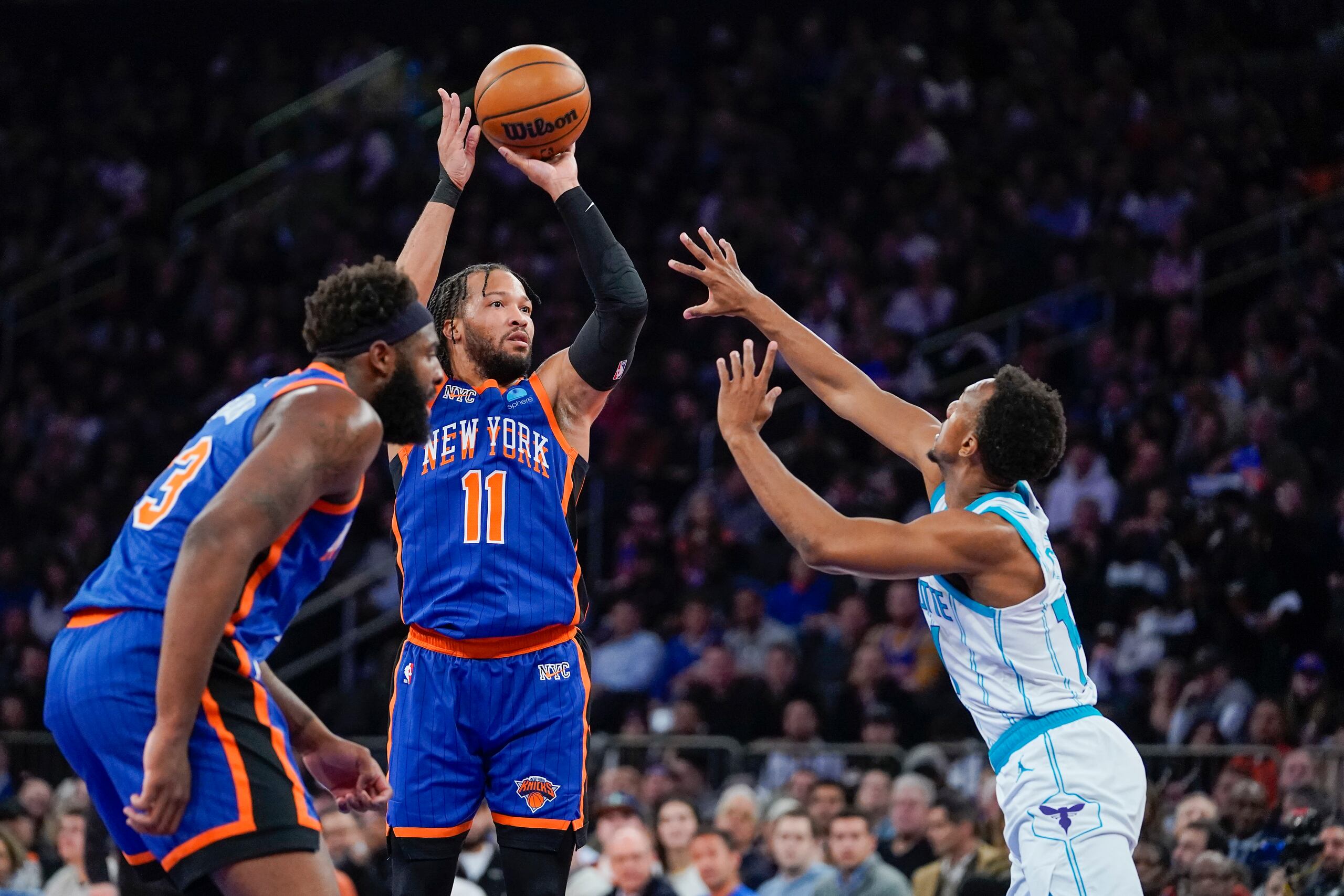 Jalen Brunson (11) lanza un balón sobre la defensa de los Charlotte Hornets, Ish Smith. Nueva York ganó el partido para obtener el último boleto de clasificación del Este a los cuartos de final de la Copa de la NBA.