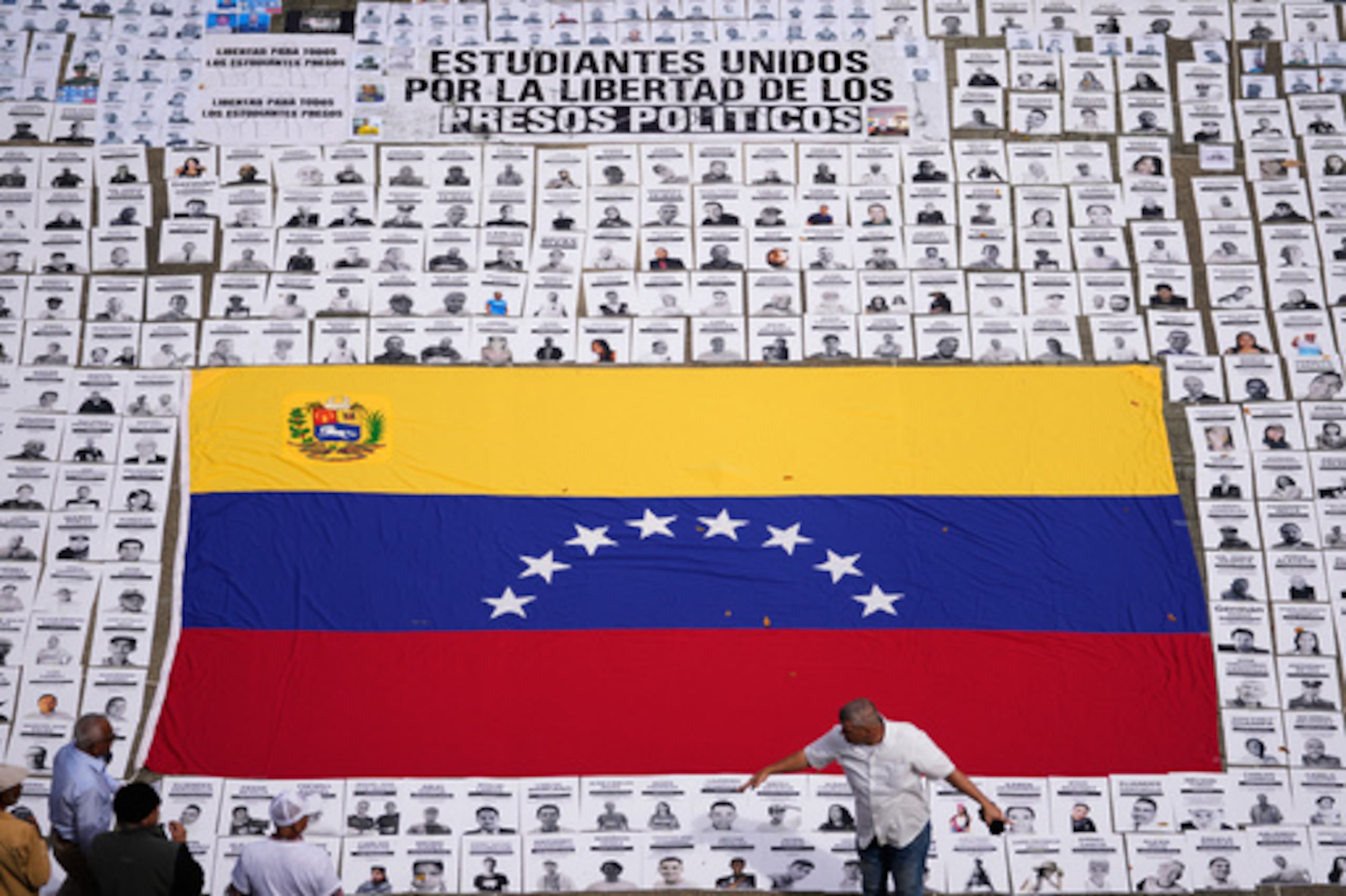 Estudiantes colocan fotos de personas que consideran presos políticos en la Universidad Central de Venezuela en Caracas, Venezuela, martes 13 de enero de 2026. (AP Photo/Matias Delacroix)