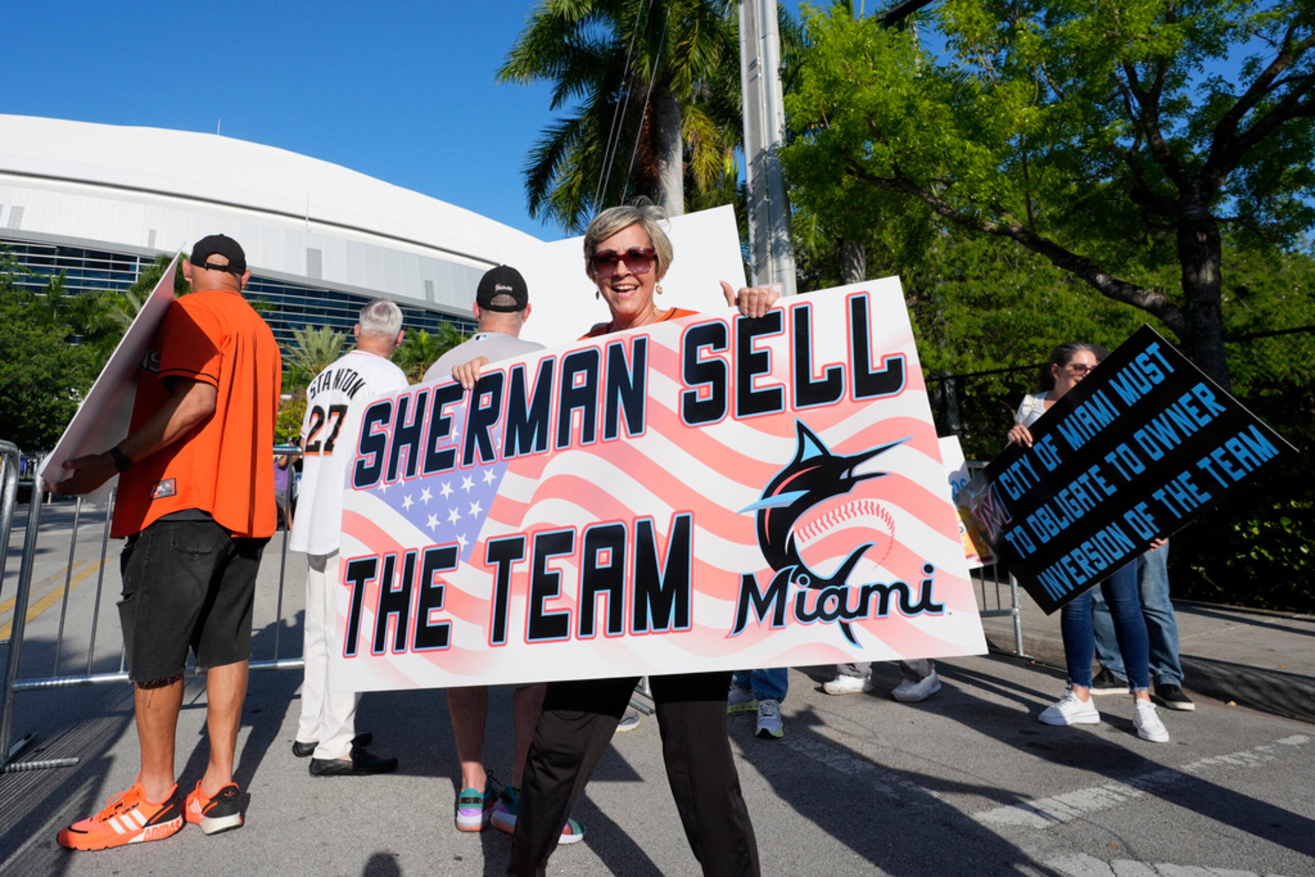 Fanáticos protestan afuera del LoanDepot Park previo al partido de béisbol entre los Marlins de Miami y los Phillies de Filadelfia.