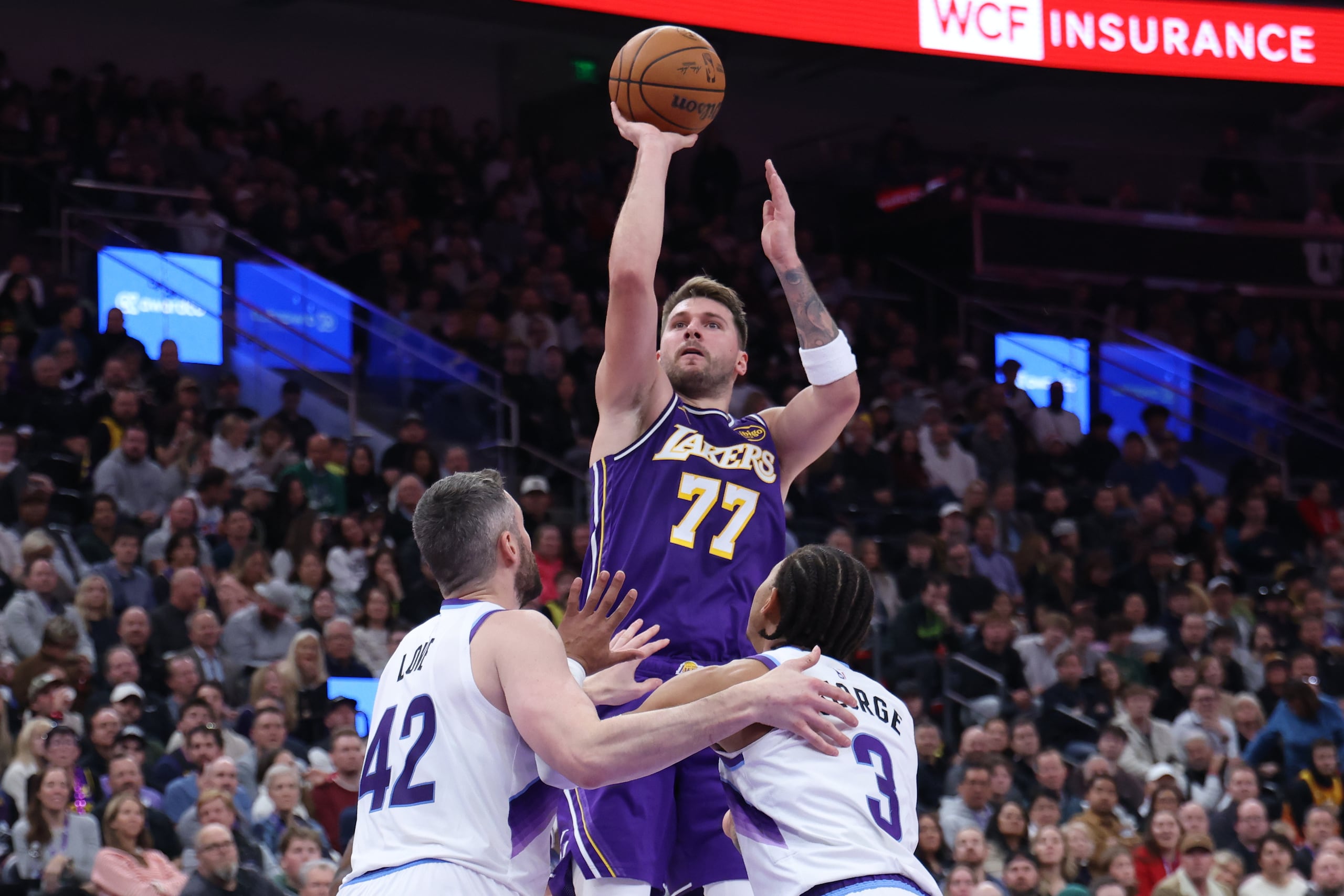 Luka Doncic, de los Lakers de Los Ángeles, lanza ante la defensa de Kevin Love y Keyonte George, ambos del Jazz de Utah.