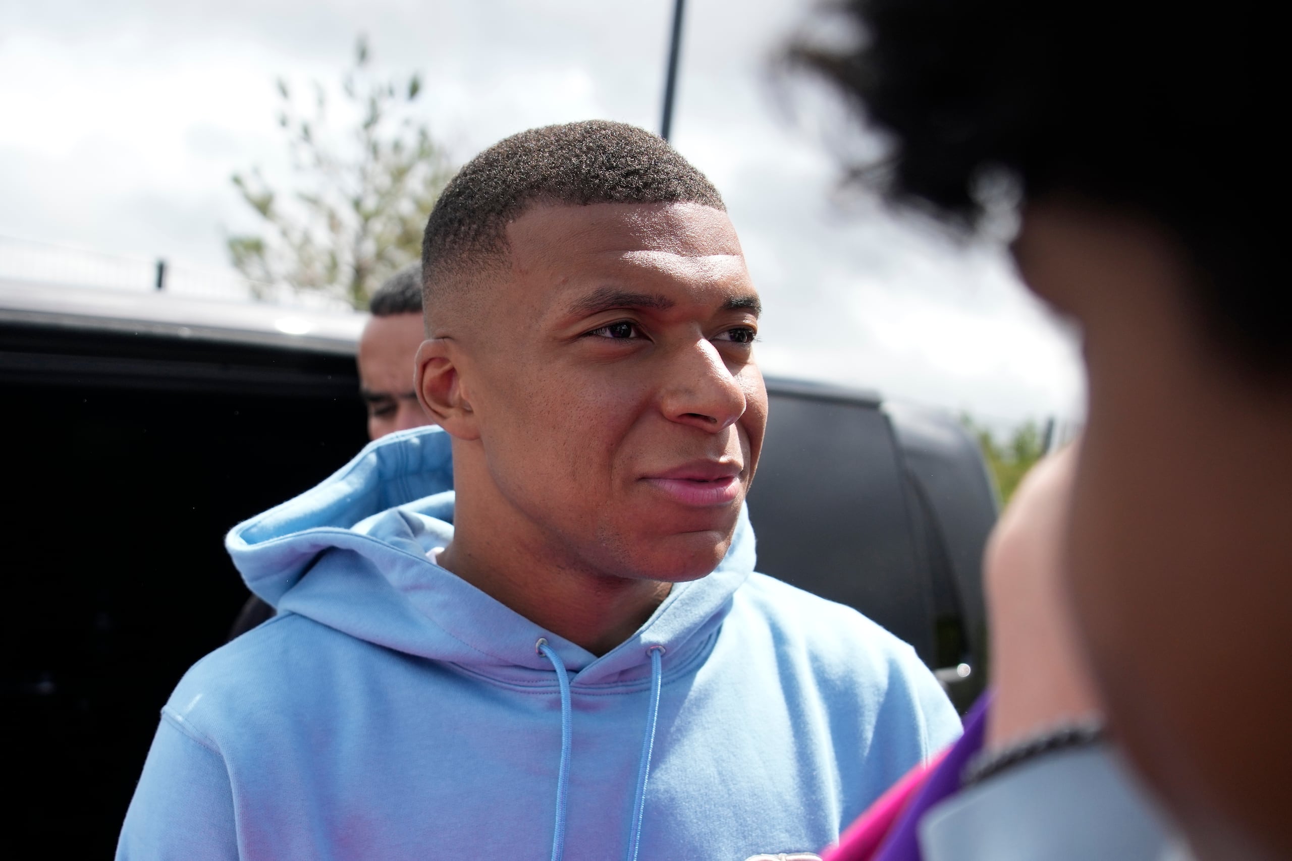 Kylian Mbappé del Paris Saint-Germain saluda a hinchas a la salida de la ciudad deportiva del club, el viernes 28 de julio de 2023, en las afueras de París. (AP Foto/Lewis Joly)