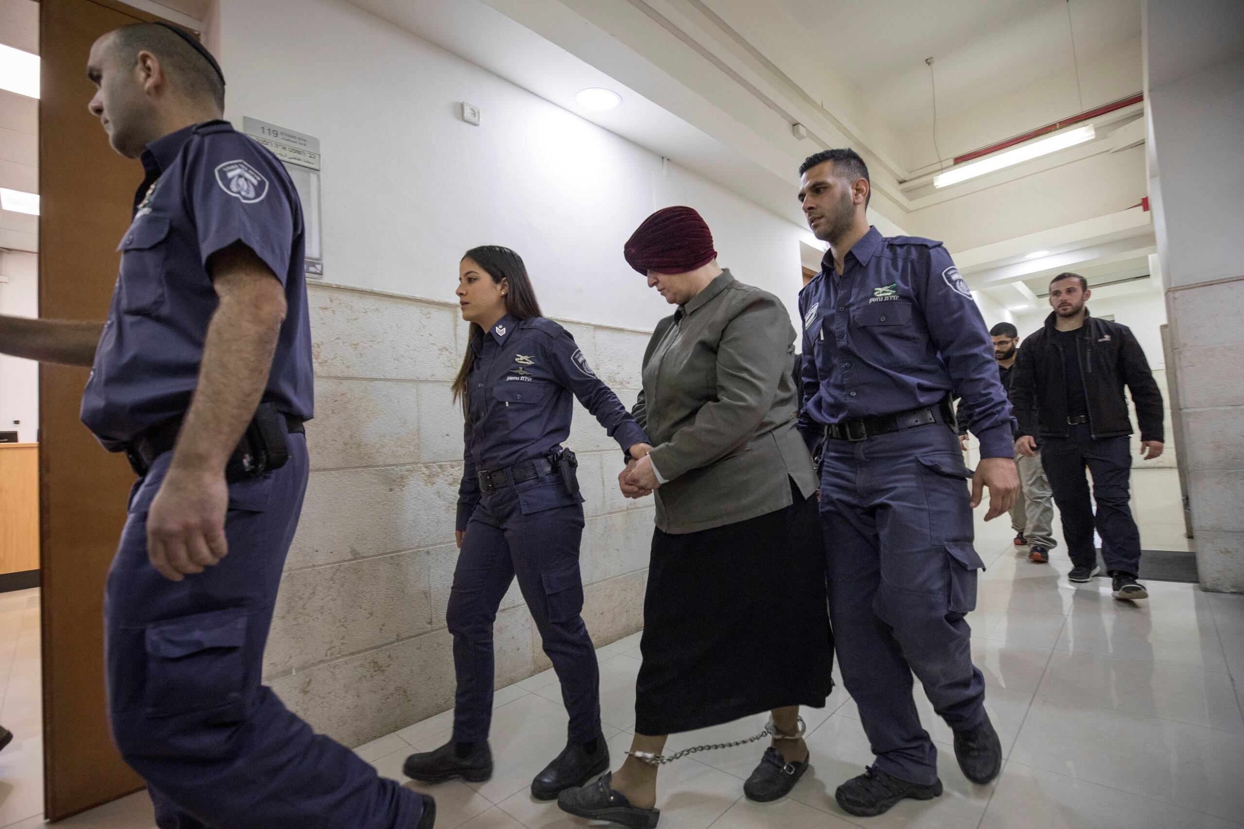 Fotografía de archivo, tomada en febrero de 2018, en la que se registró a Malka Leifer (c), exdirectora de una escuela judía ultraordoxa en Melbourne (Australia), al ser conducida y esposada por guardias del servicio penitenciario israelí, en Jerusalén. Leifer fue extraditada desde Israel y condenada este martes a quince años de cárcel por abusos sexuales a dos adolescentes entre 2004 y 2007. EFE/Atef Safadi