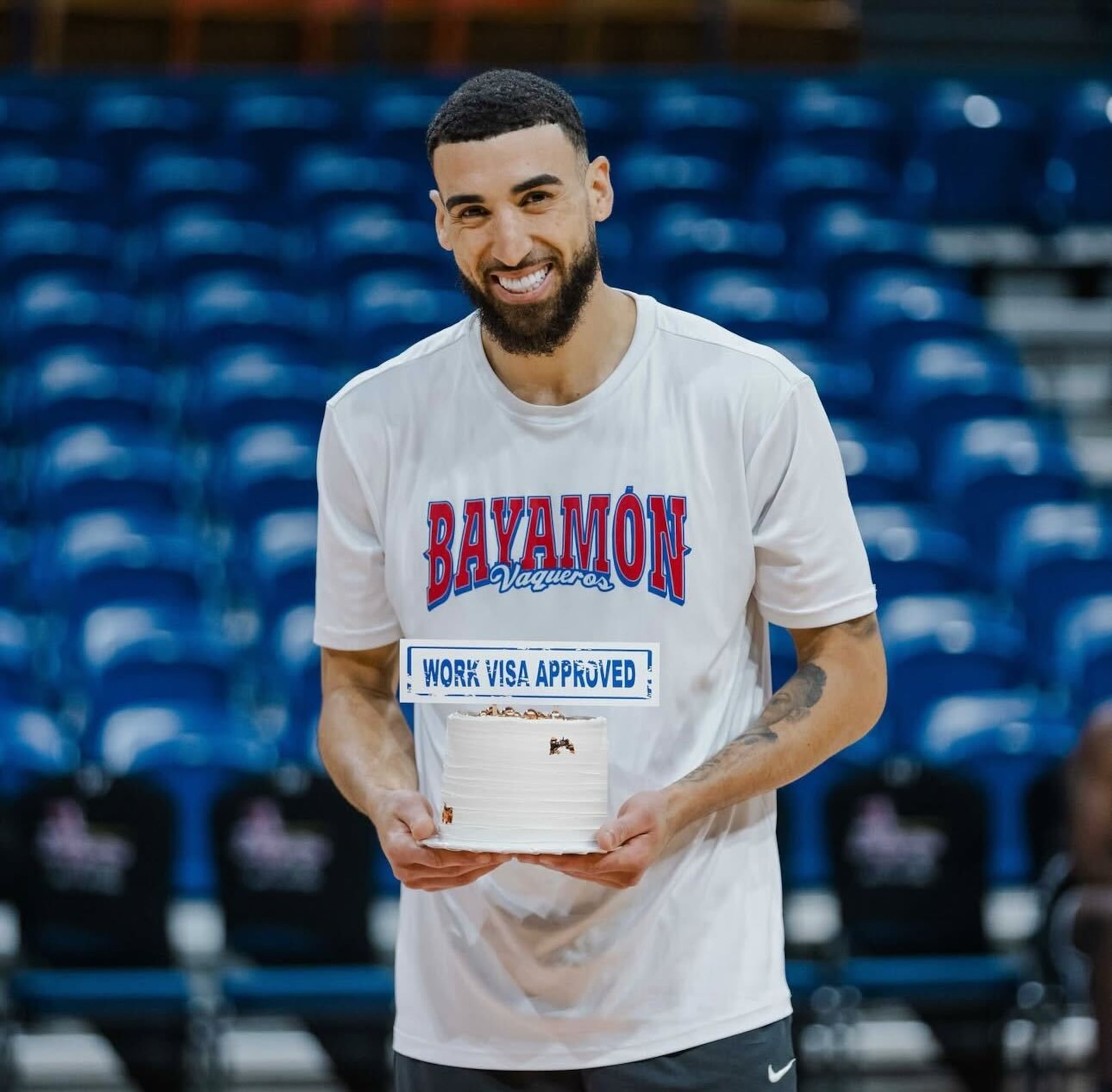 Chris Duarte con un bizcoho que le obsequiaron los Vaqueros de Bayamón después de que su visa de trabajo fuese aprobada.