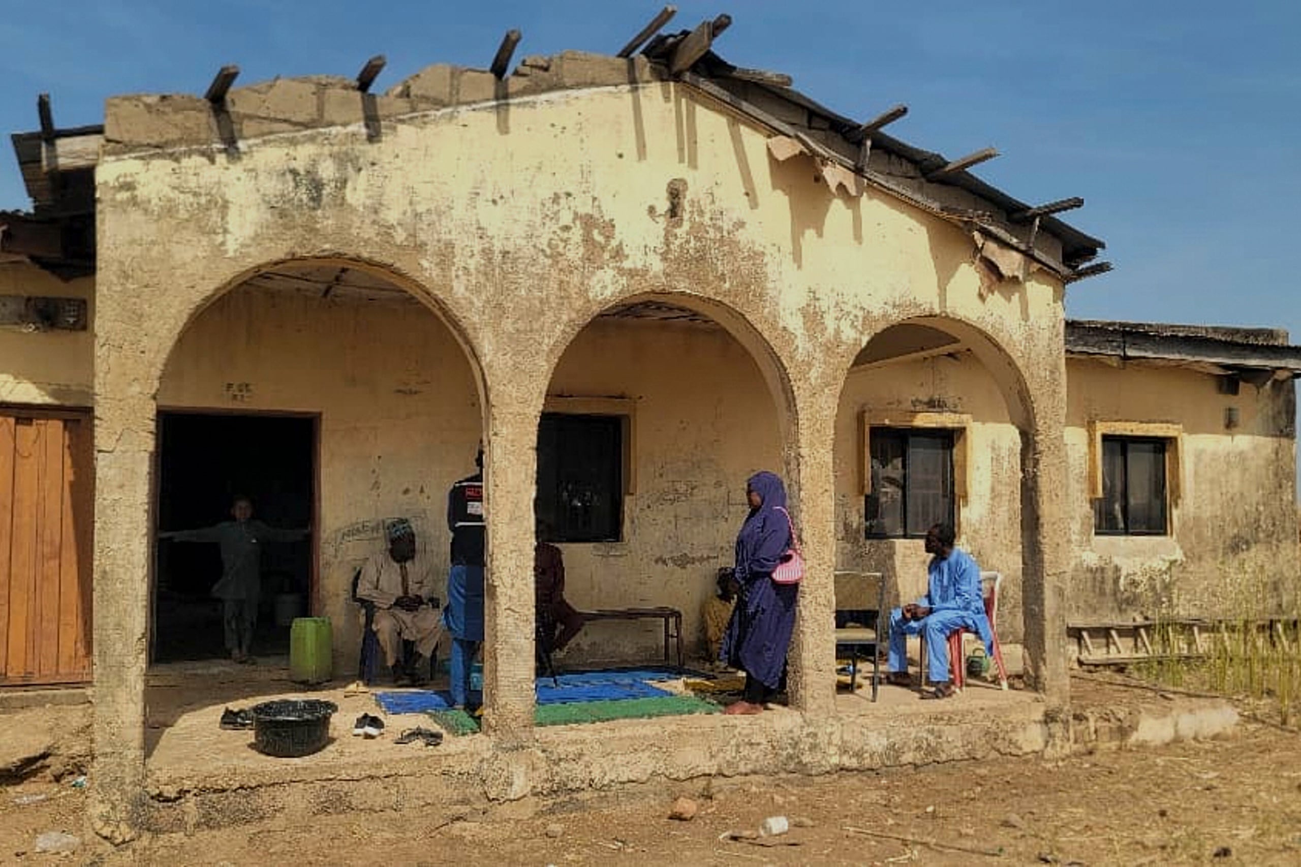 Los dolientes se reúnen en la casa de Hassan Yakubu Makuku, subdirector de la Escuela Secundaria Pública para Chicas, donde ayer hombres armados secuestraron a 25 niñas y lo mataron, en Kebbi, Nigeria, el martes 18 de noviembre de 2025. (Foto AP/Tunde Omolehin)