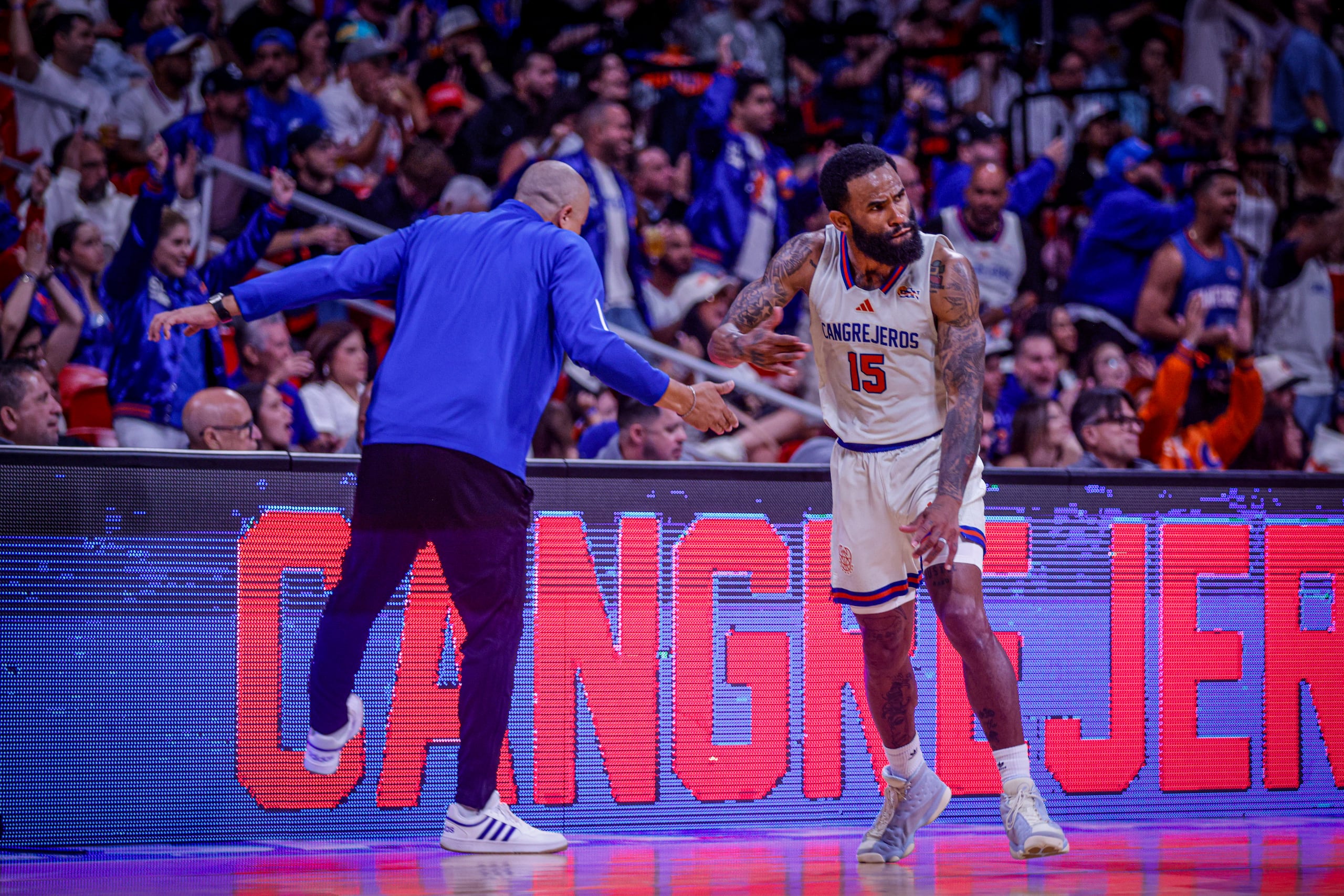 Walter Hodge Jr. celebra con el dirigente Nelson Colón después de anotar ante los Criollos de Caguas en el primer juego de los cuartos de final del BSN.