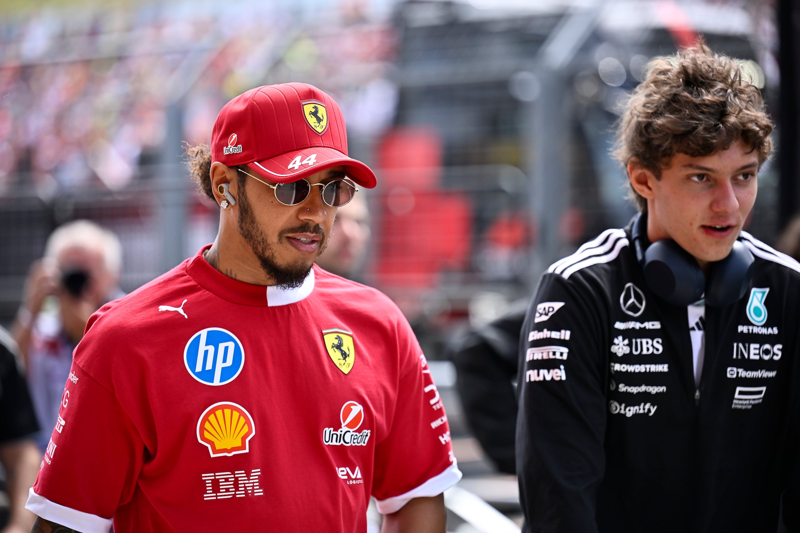 Lewis Hamilton, izquierda, piloto británido de Ferrari, llega para el desfile de pilotos en el circuito Hungaroring, en Mogyorod, Hungría, el domingo 3 de agosto de 2025, previo al Gran Premio de Hungría de F1. (AP Foto/Denes Erdos)