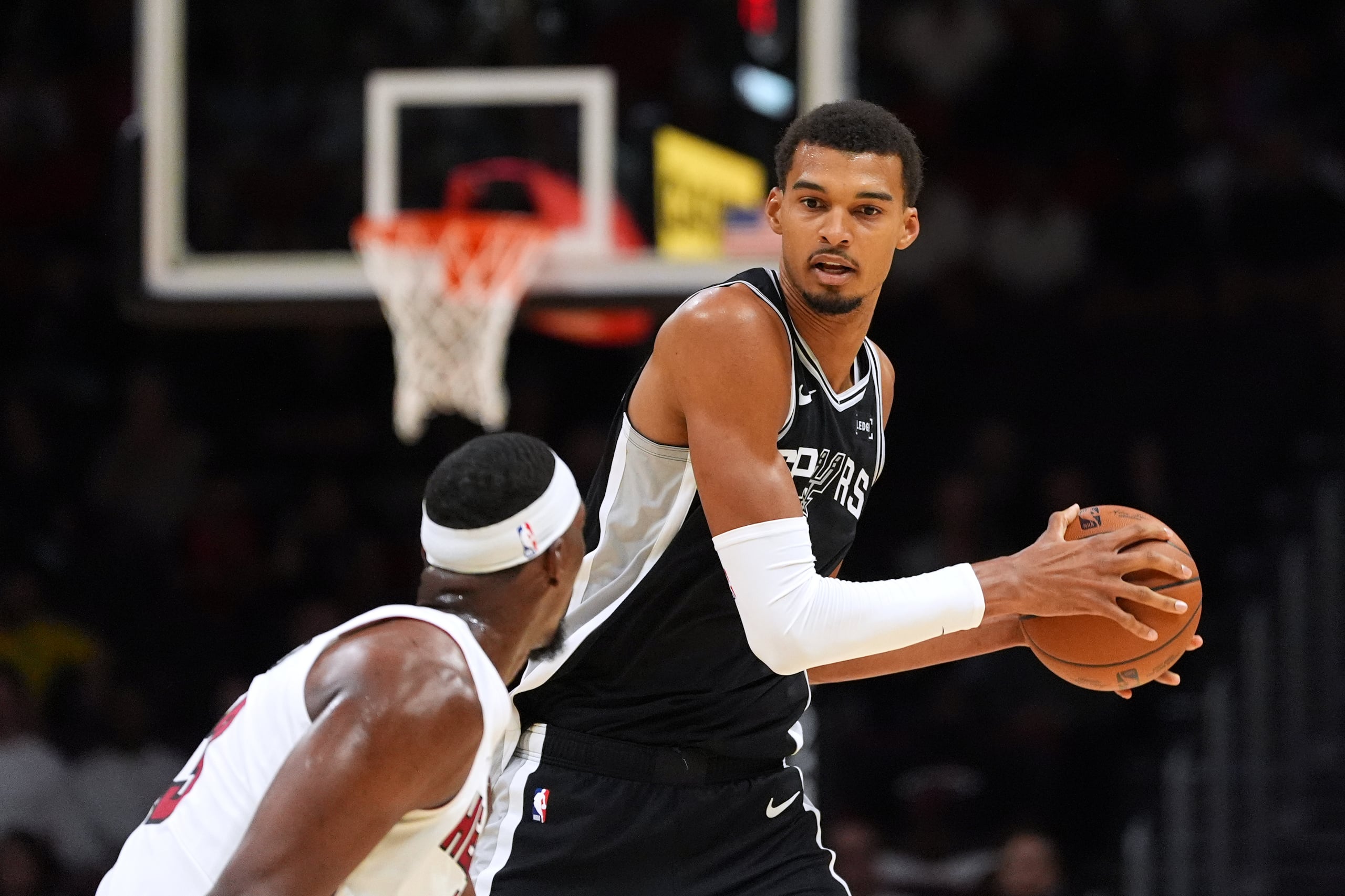 Victor Wembanyama, de los Spurs de San Antonio encara la marca defensiva de Bam Adebayo, del Heat de Miami, durante la primera mitad del juego de pretemporada del baloncesto de la NBA, el miércoles 8 de octubre de 2025, en Miami. (AP Foto/Rebecca Blackwell)