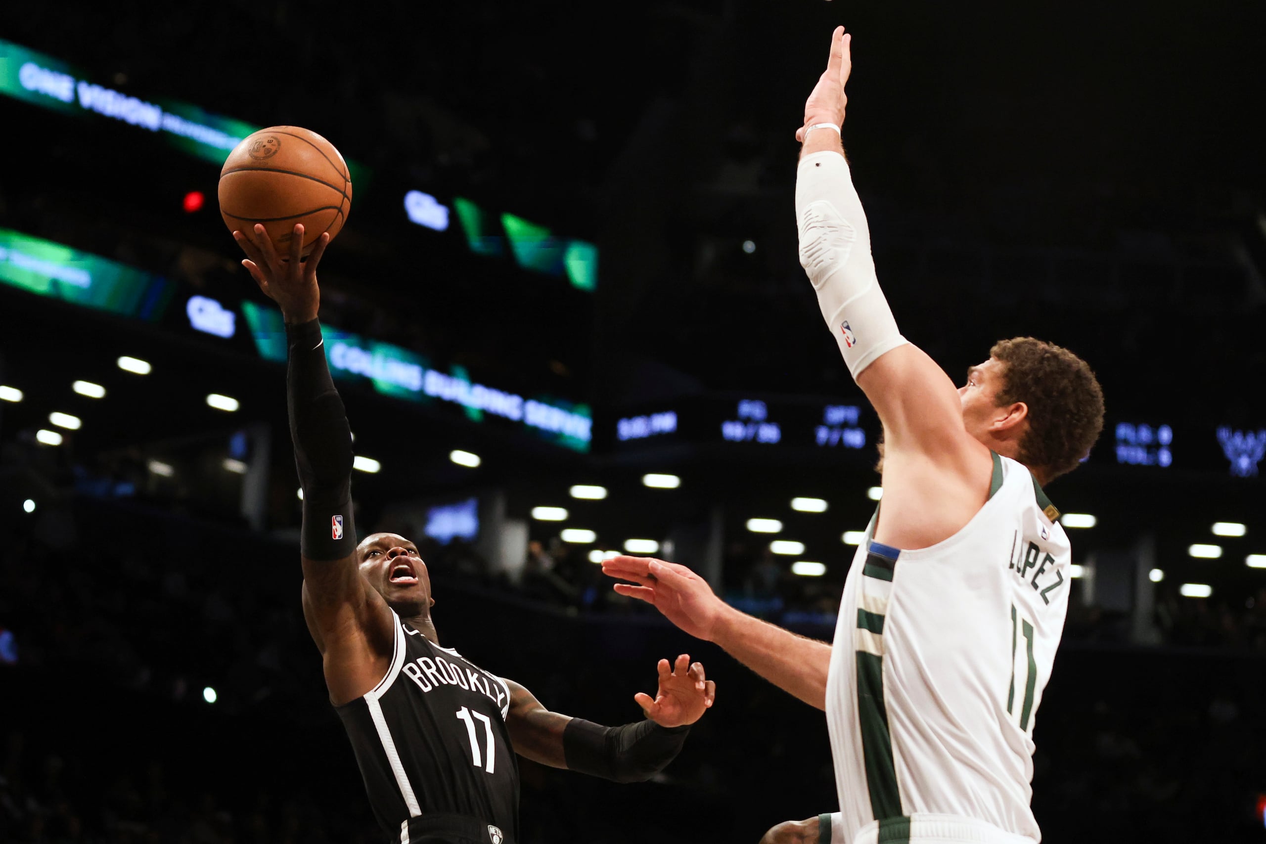 Dennis Schroder, a la izquierda, aparece aquí lanzando una pelota frente a la defensa de Brook Lopez de Milwaukee.