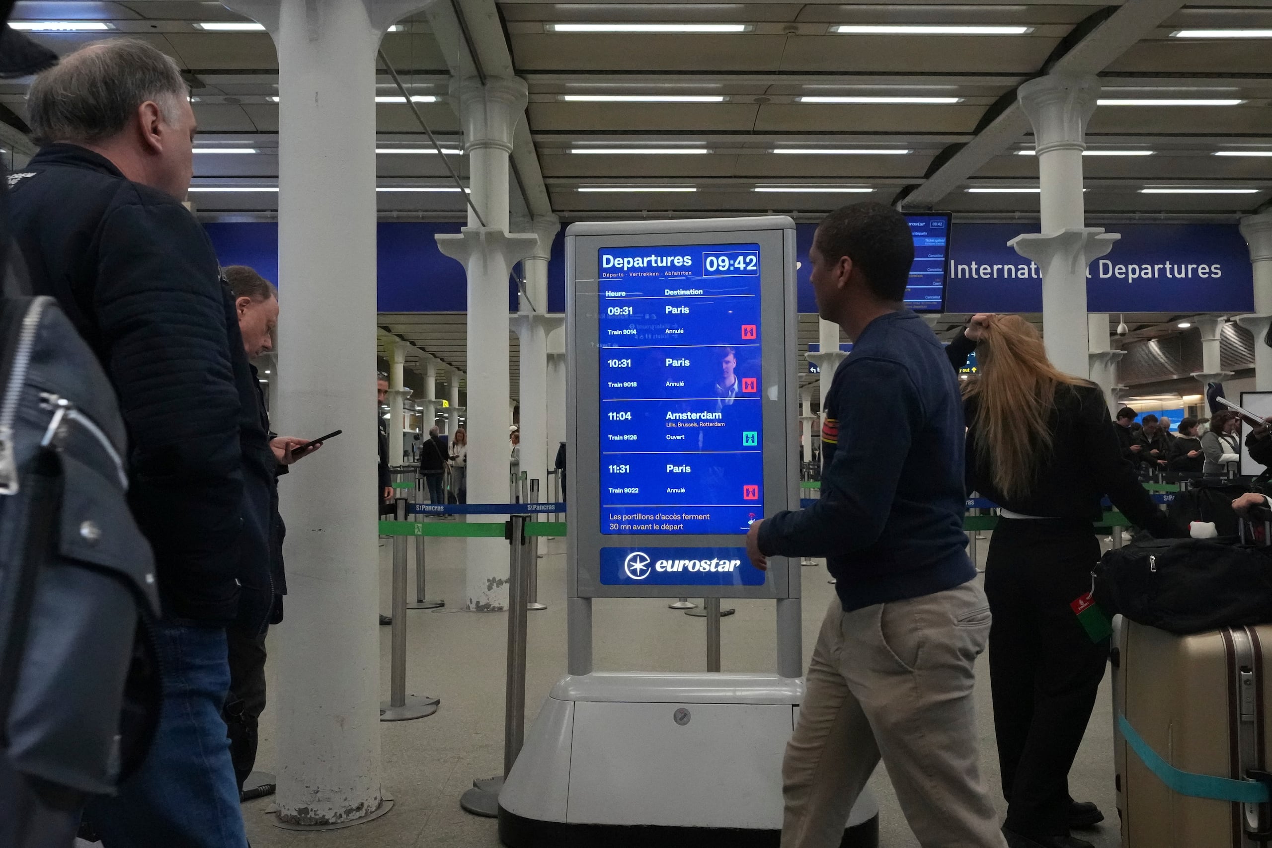 Passengers react at St Pancras Station, London, to news that Eurostar services to Paris have been suspended, Friday, March 7, 2025, the trains have been halted due to an unexploded World War II bomb near the tracks in Paris. (AP Photo/Frank Augstein)