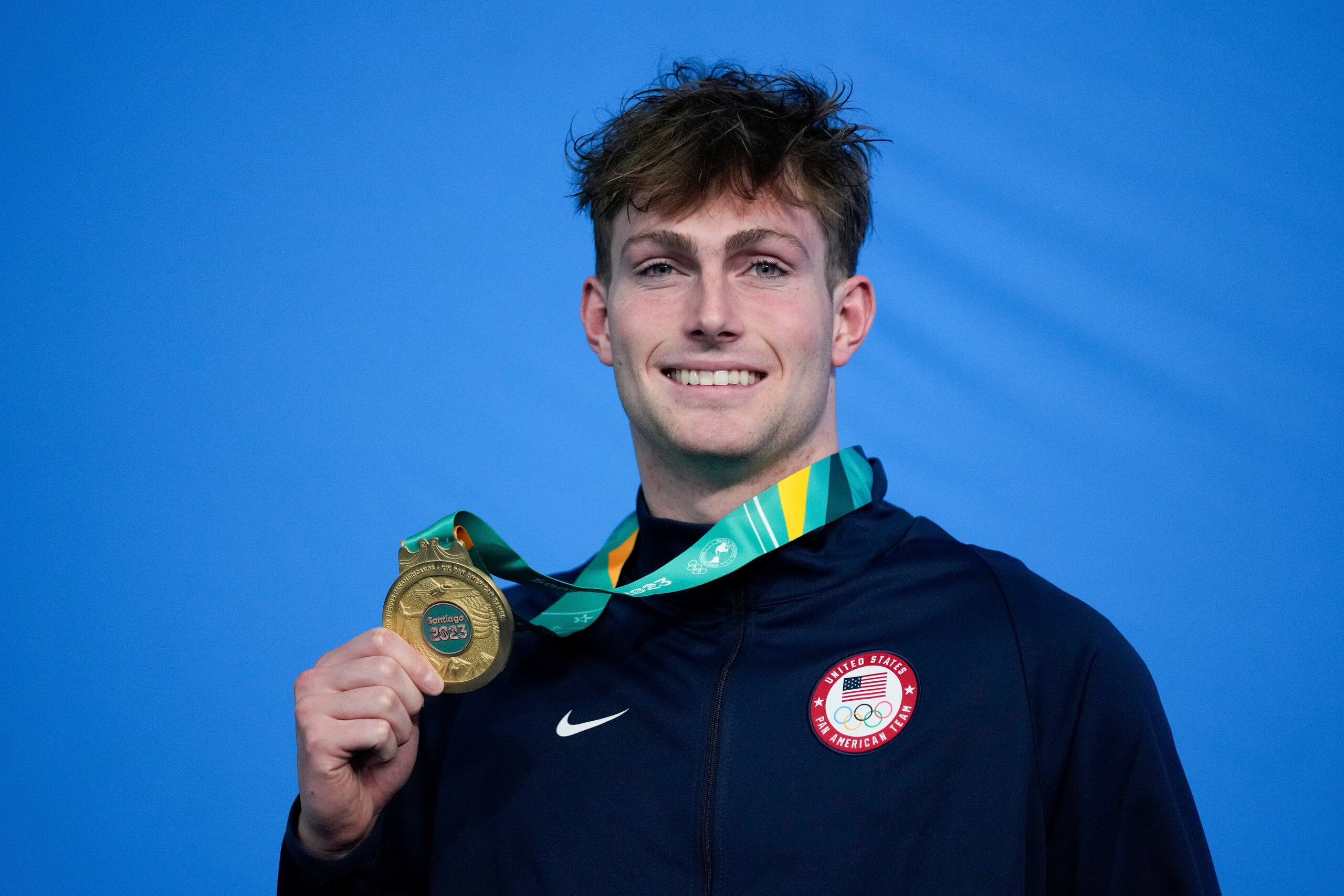 El estadounidense Jack Aikins posa con su medalla de oro en el podio de los 200 metros espalda de la natación de los Juegos Panamericanos en Santiago, Chile, el domingo 22 de octubre de 2023. (AP Foto/Silvia Izquierdo)
