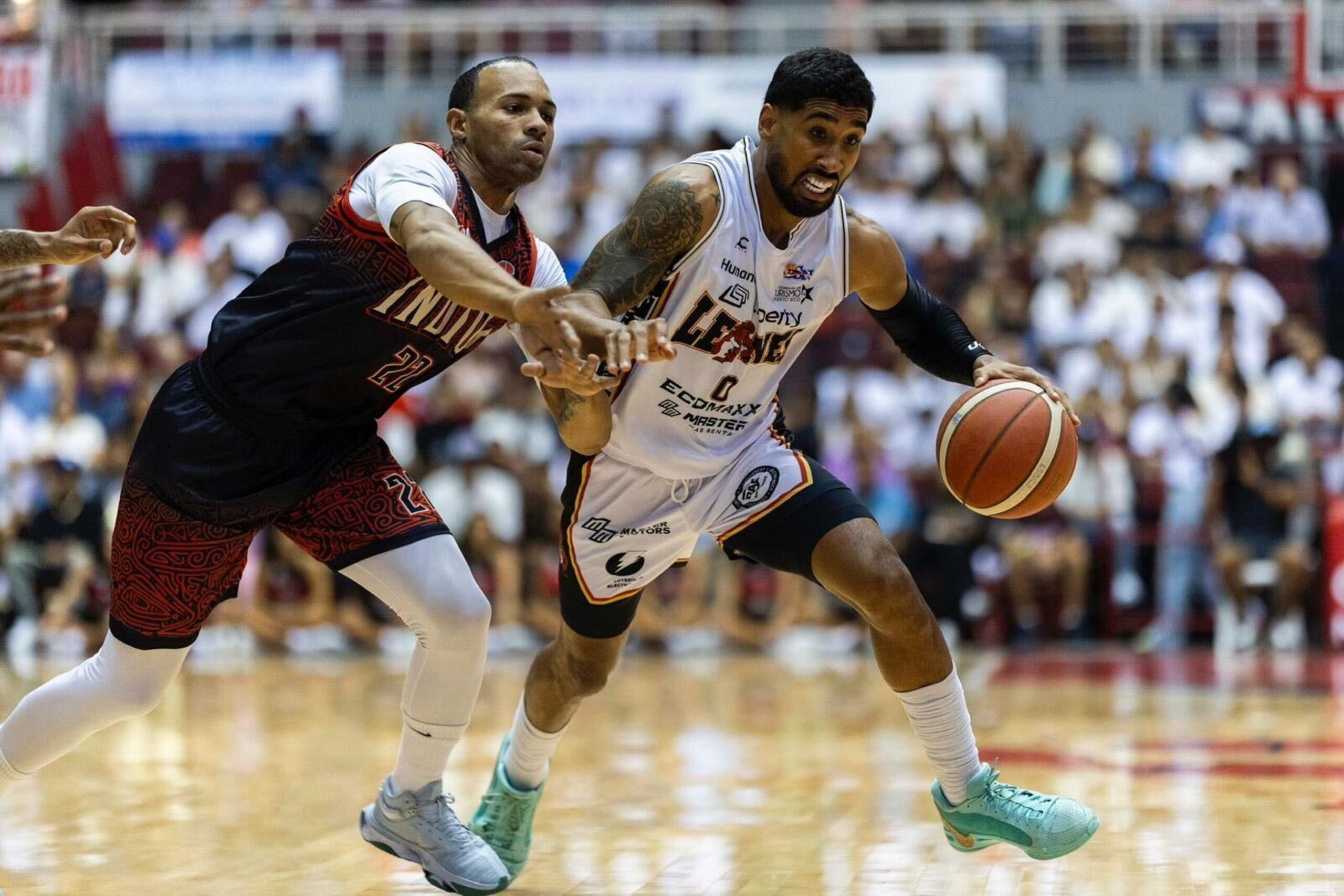 Jezreel De Jesús, de los Leones de Ponce, maneja el balón frente a Jeff Early Jr., de los Indios de Mayagüez.