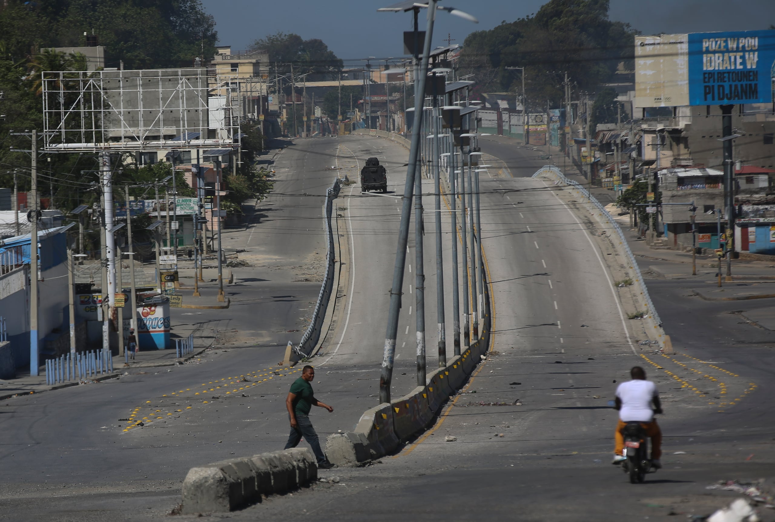 Un vehículo blindado circula por una calle principal que está vacía debido a los enfrentamientos entre la policía y las pandillas en el barrio de Delmas, en Puerto Príncipe, Haití, el miércoles 12 de febrero de 2025. (AP Foto/Odelyn Joseph)