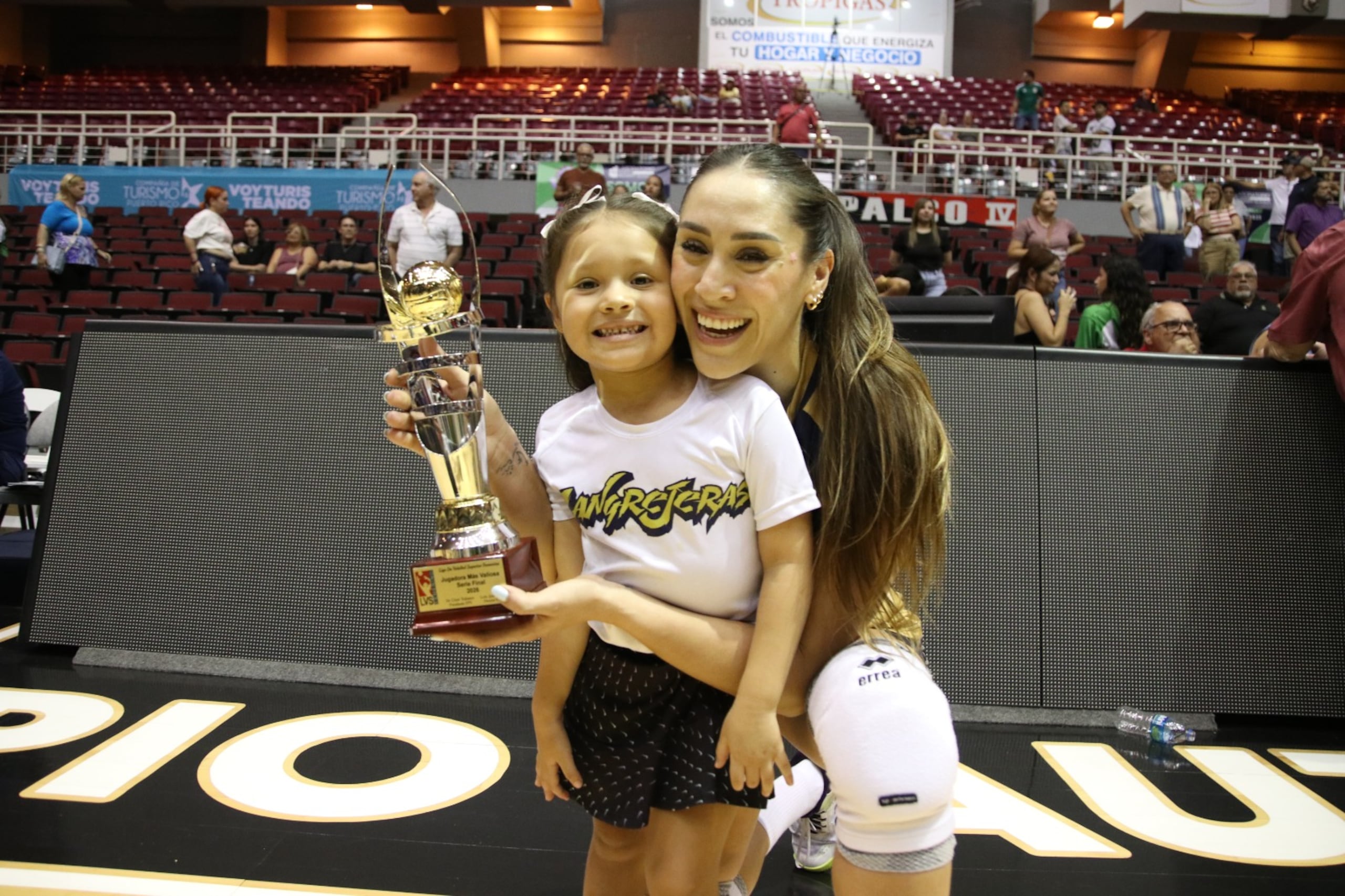 Andrea Rangel posa junto a su hija con el trofeo de Jugadora Más Valiosa.