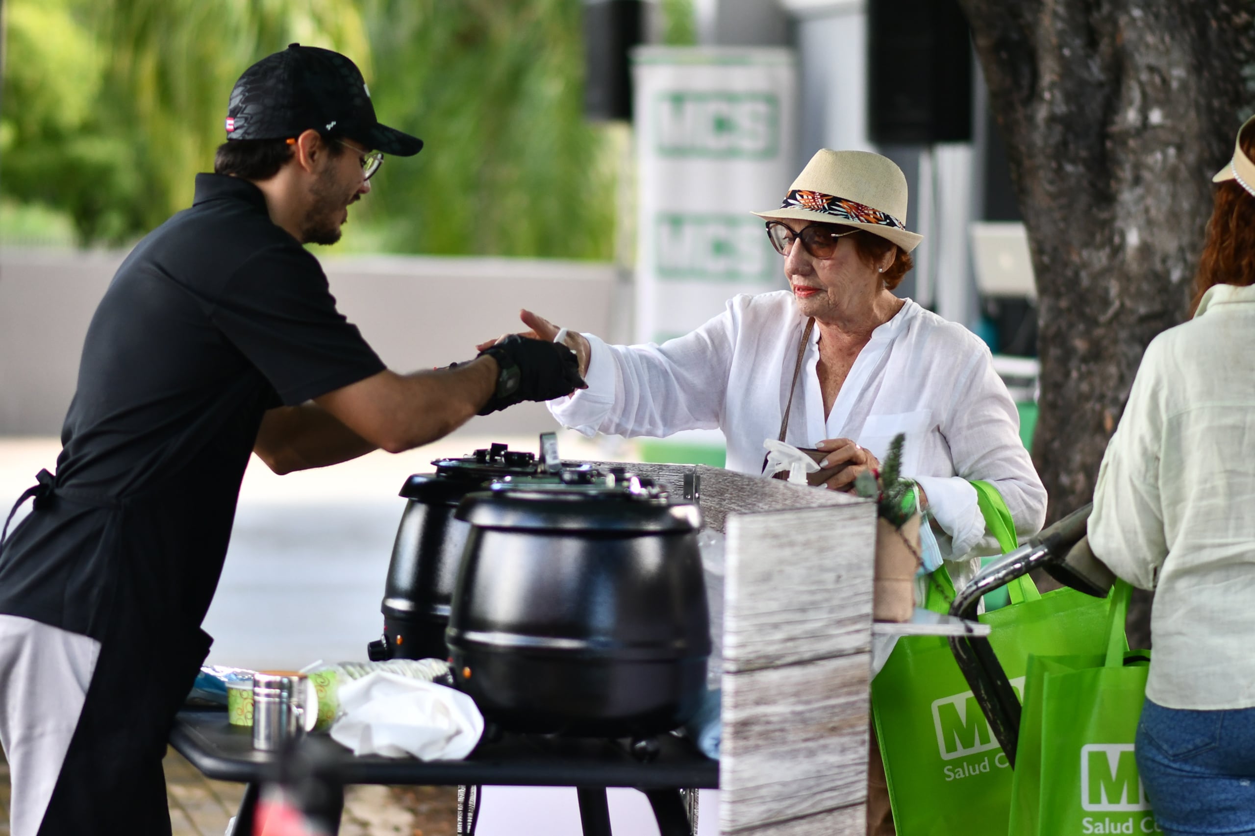 Voluntario de evento de MCS Club Te Paga sirviendo comida a participante.