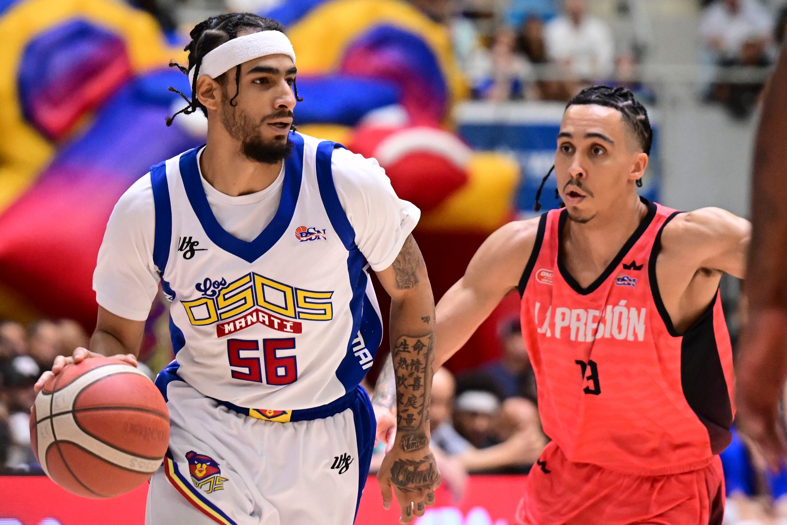 Jhivvan Jackson, de los Osos de Manatí, controla el balón ante Travis Trice, de los Criollos de Caguas, en el sexto juego de la final 2024 del BSN.