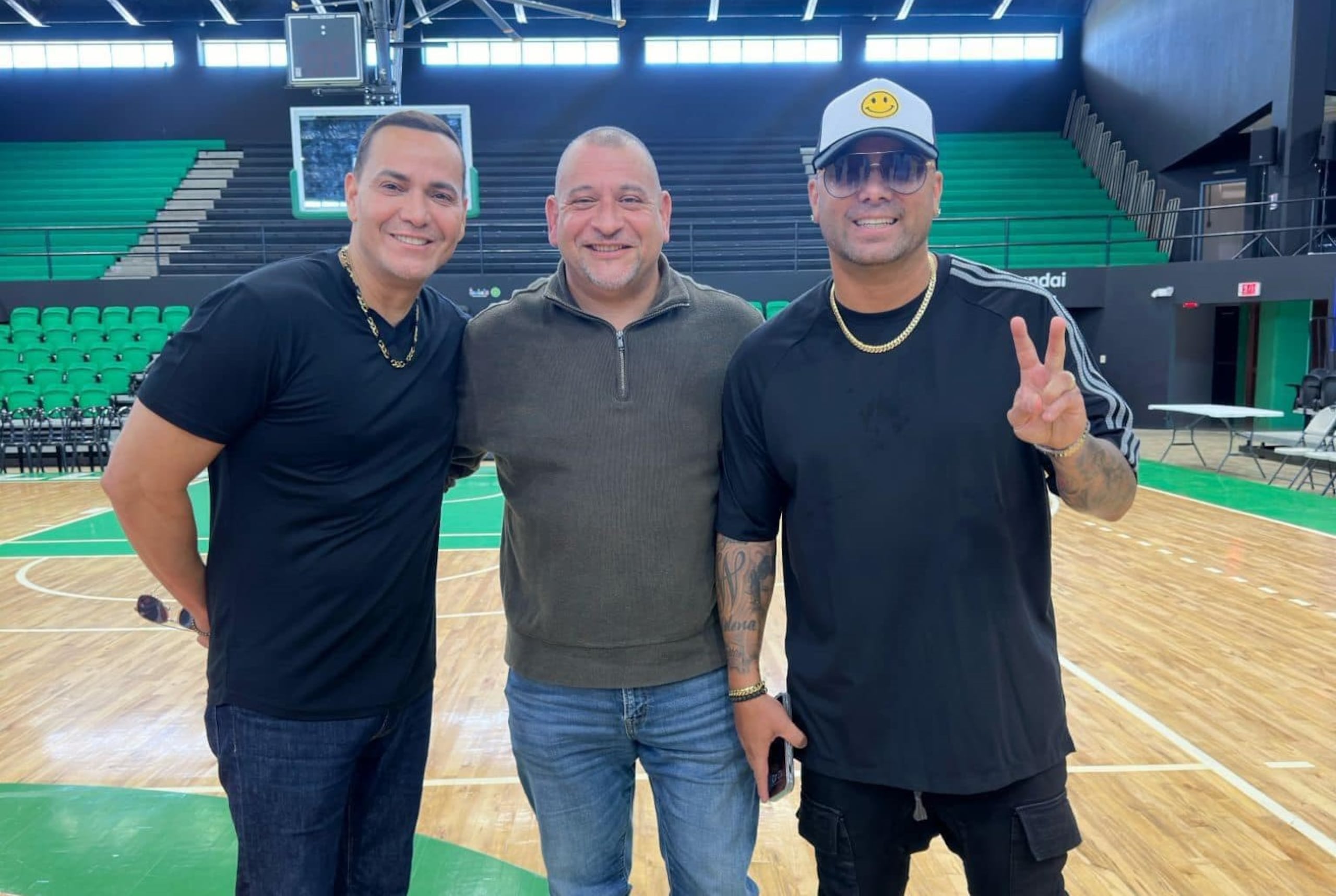 El alcalde de Isabela, Miguel "Ricky" Méndez, posa junto con Víctor Manuelle (izquierda) y Wisin en una visita al Coliseo José "Buga" Abreu.