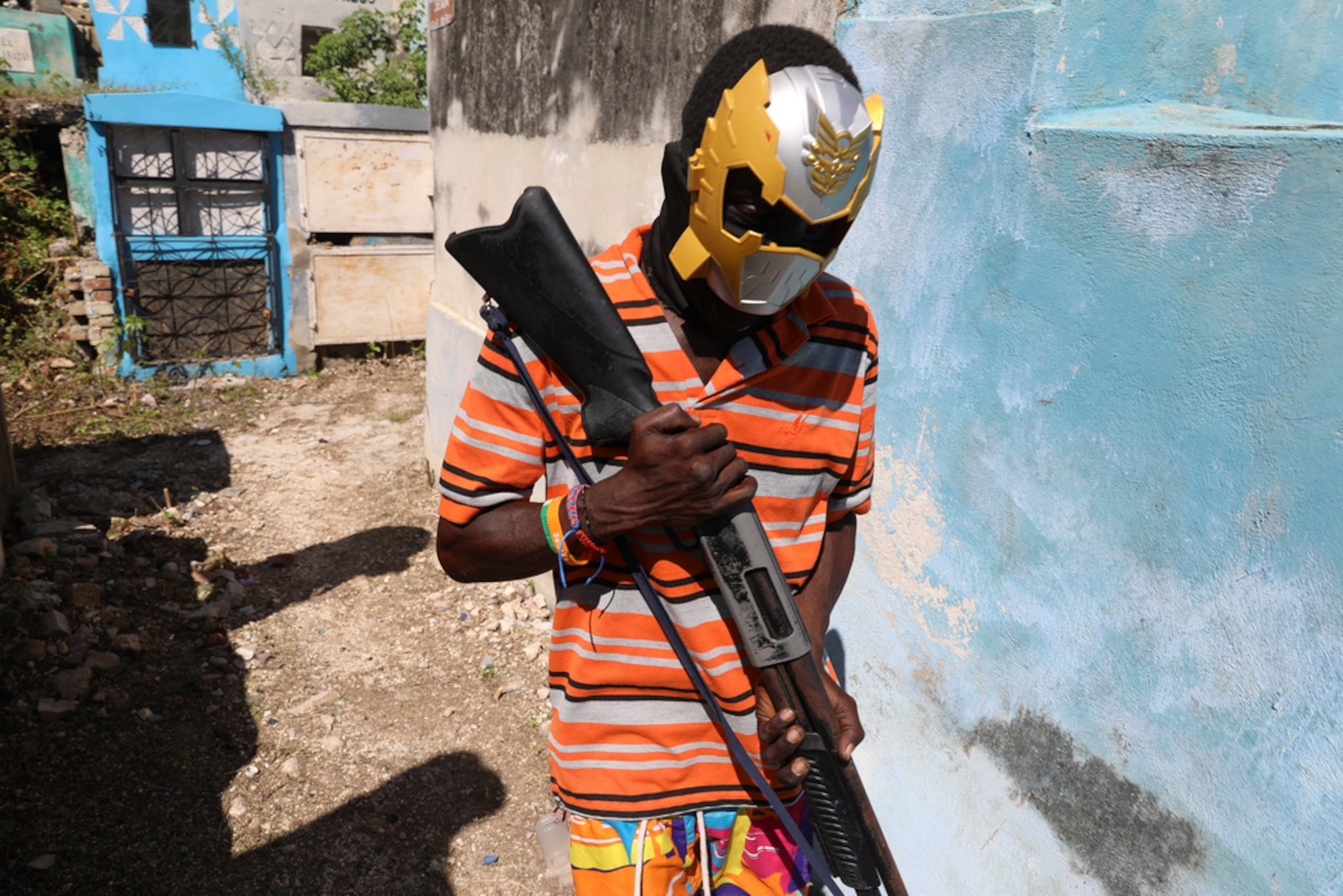 Un miembro enmascarado y armado de una banda posa para una foto en el Cementerio Nacional durante el festival Fete Gede, que celebra el Día de los Muertos para honrar los espíritus haitianos del Vodú, Baron Samedi y Gede, en Puerto Príncipe el 1 de noviembre de 2024.