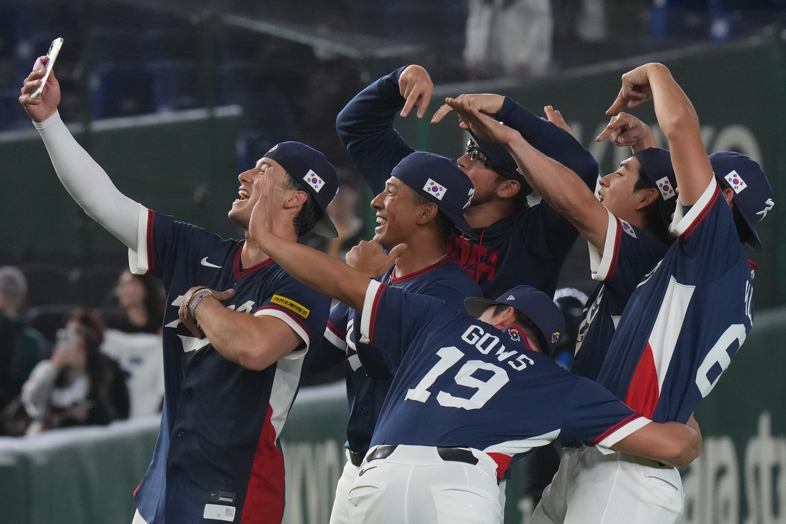 Los jugadores de Corea del Sur se sacan selfies al festajar la victoria ante Australia en el Clásico Mundial de béisbol, el lunes 9 de marzo de 2026, en Tokio. (AP Foto/Eugene Hoshiko)