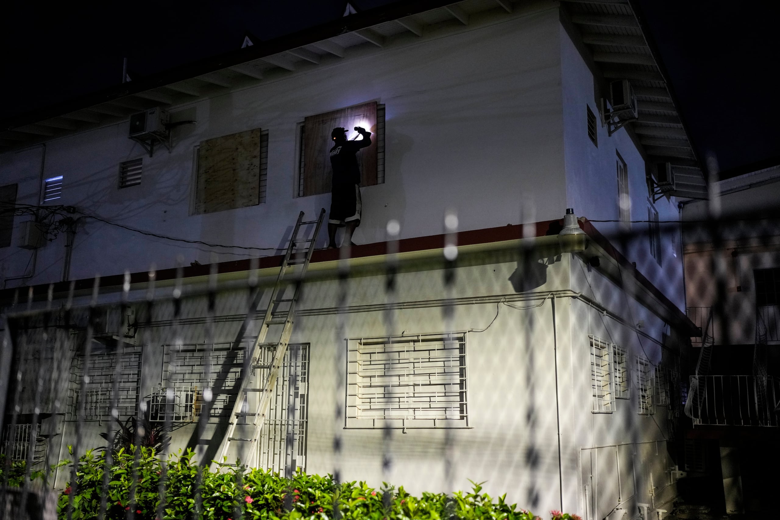 Un hombre tapia las ventanas de un hotel preparándose para la llegada prevista del huracán Melissa a Kingston, Jamaica, el sábado 25 de octubre de 2025. (Foto AP/Matias Delacroix)