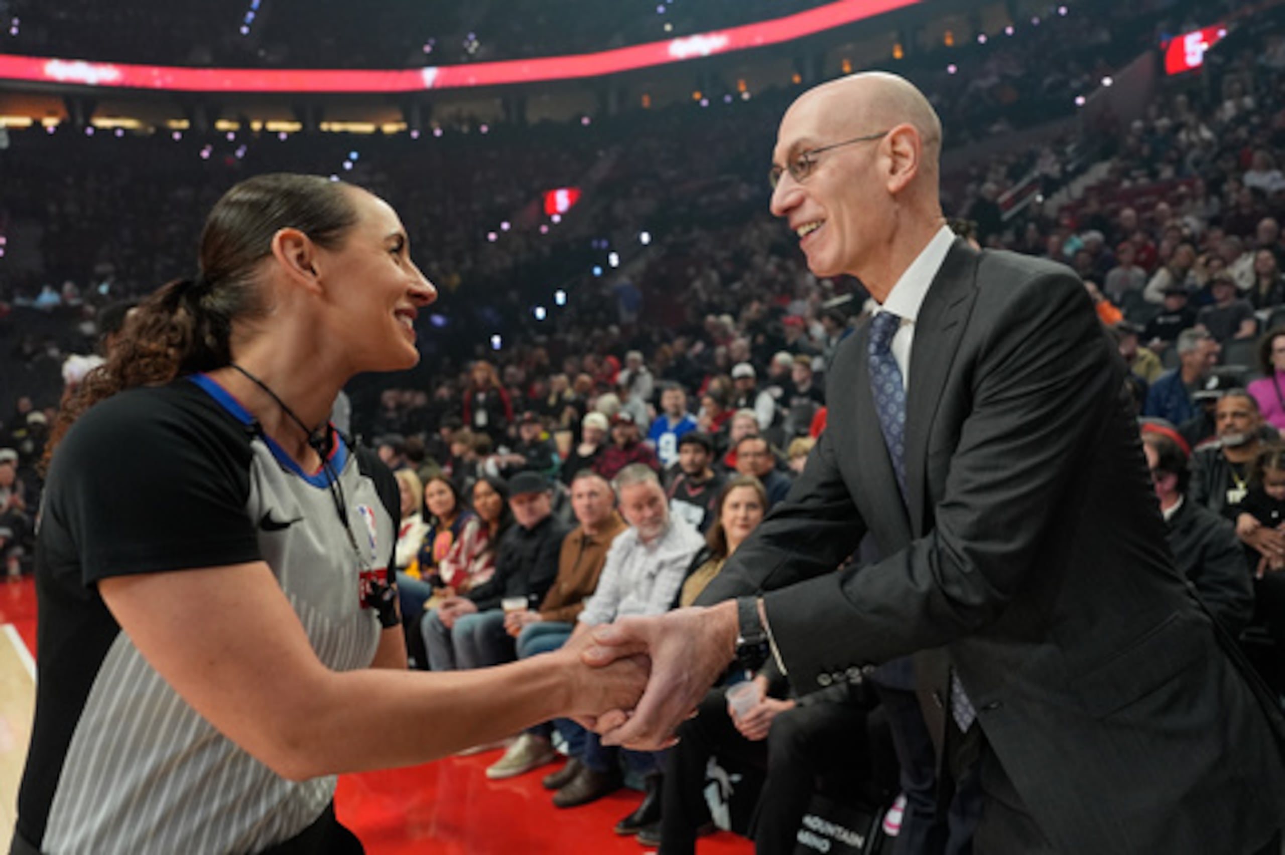 El comisionado de la Adam Silver saluda a la árbitro Ashley Moyer-Gleich previo al partido entre los Trail Blazers de Portland y el Jazz de Utah, el viernes 13 de marzo de 2026, en Portland. (AP Fhoto/Jenny Kane)