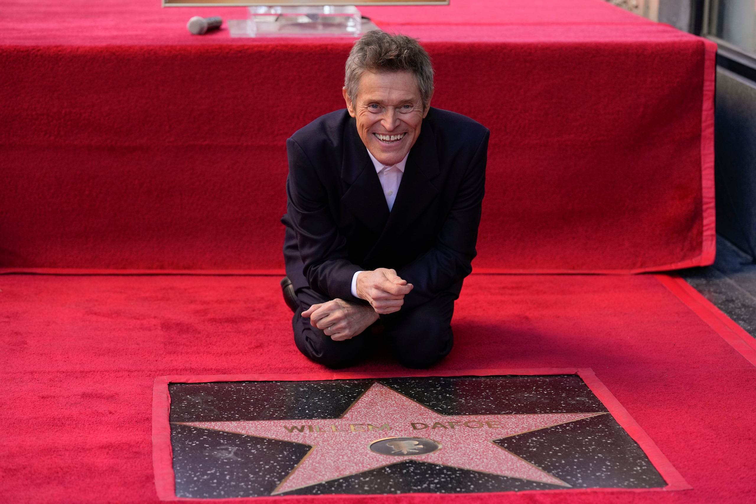 Willem Dafoe toca su nueva estrella en una ceremonia en su honor con la estrella en el Paseo de la Fama de Hollywood, el lunes 8 de enero de 2024, en Los Ángeles. (AP Photo/Chris Pizzello)