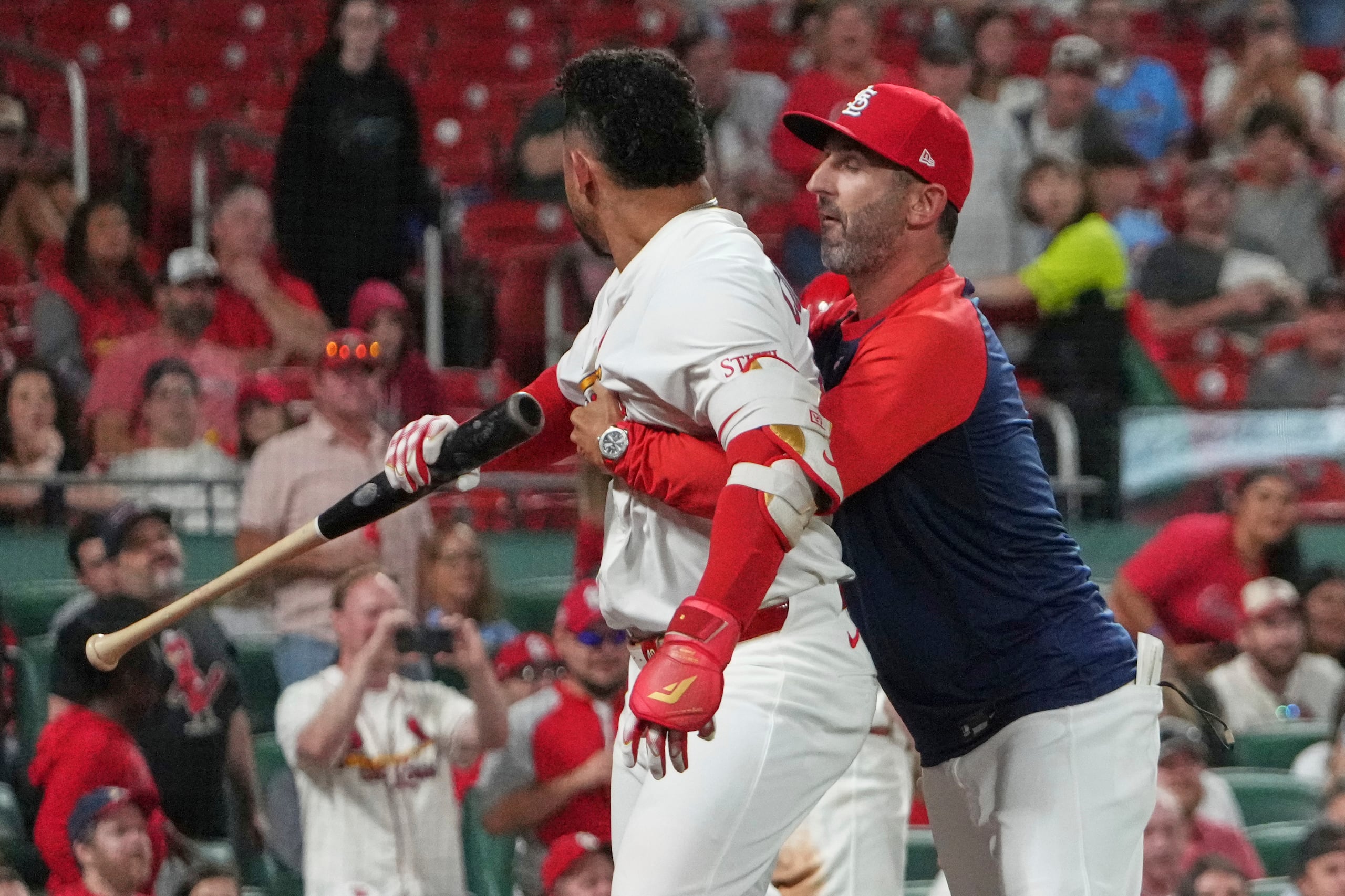 Willson Contreras, pelotero venezolano de los Cardenales de San Luis, es detenido por el coach de banca Daniel Descalso, tras su expulsión del duelo ante los Piratas de Pittsburgh, el lunes 25 de agosto de 2025 (AP Foto/Jeff Roberson)